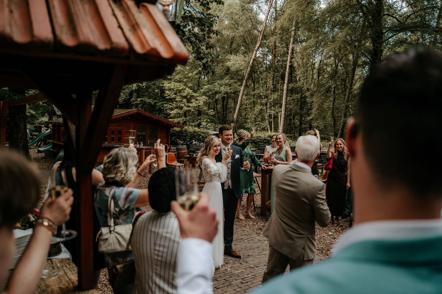 Guests taking photos at rustic outdoor wedding celebration.