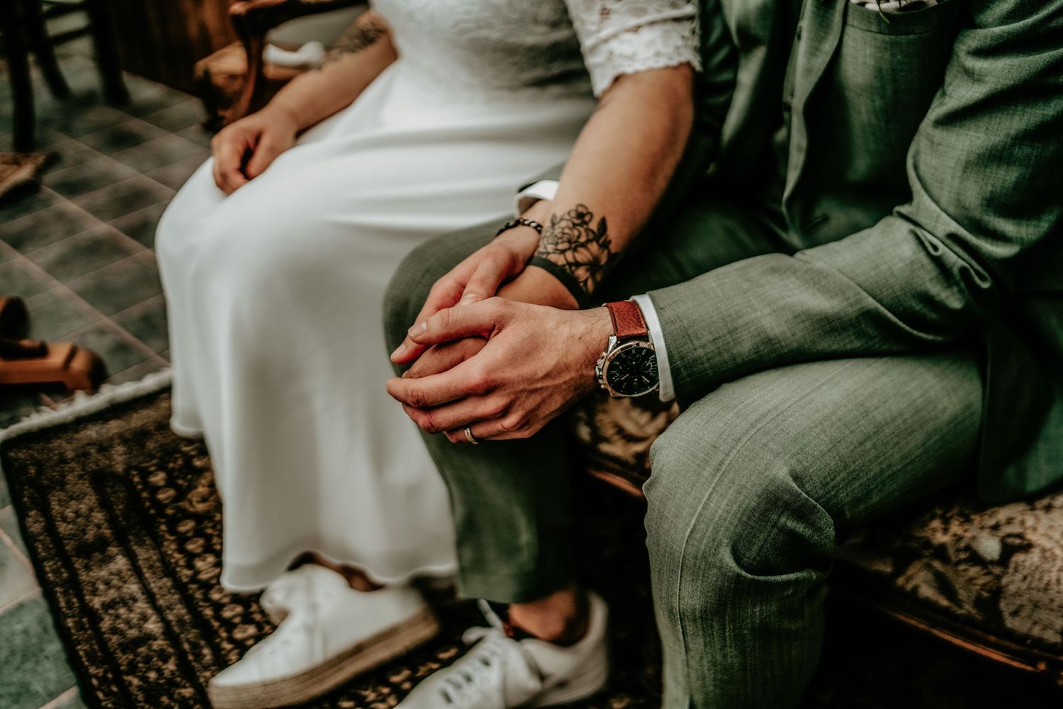 Close-up detail shot of couple's hands during an intimate wedding ceremony moment.