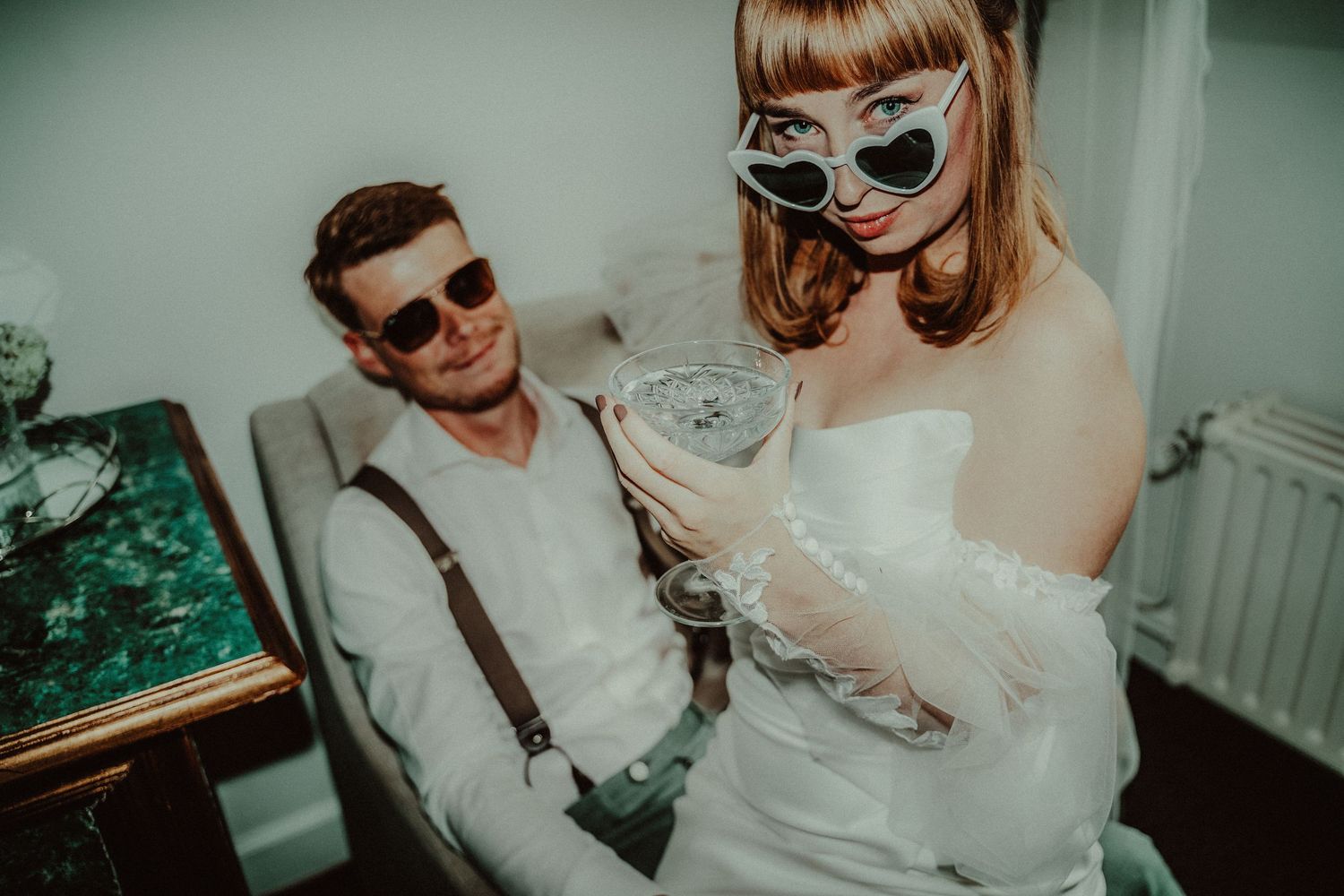 Retro-styled wedding scene with couple in sunglasses and vintage-inspired attire.