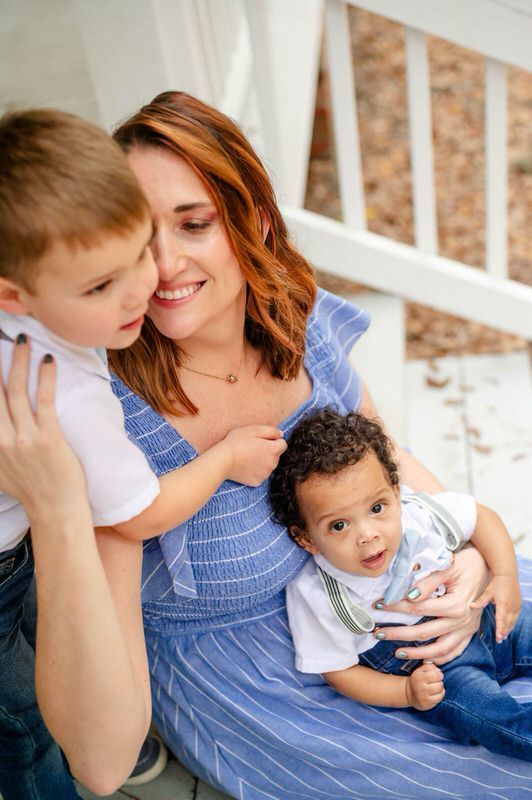 Family of mom and two boys snuggling together at Alpine Groves park during a pose in a family photoshoot in Jacksonville