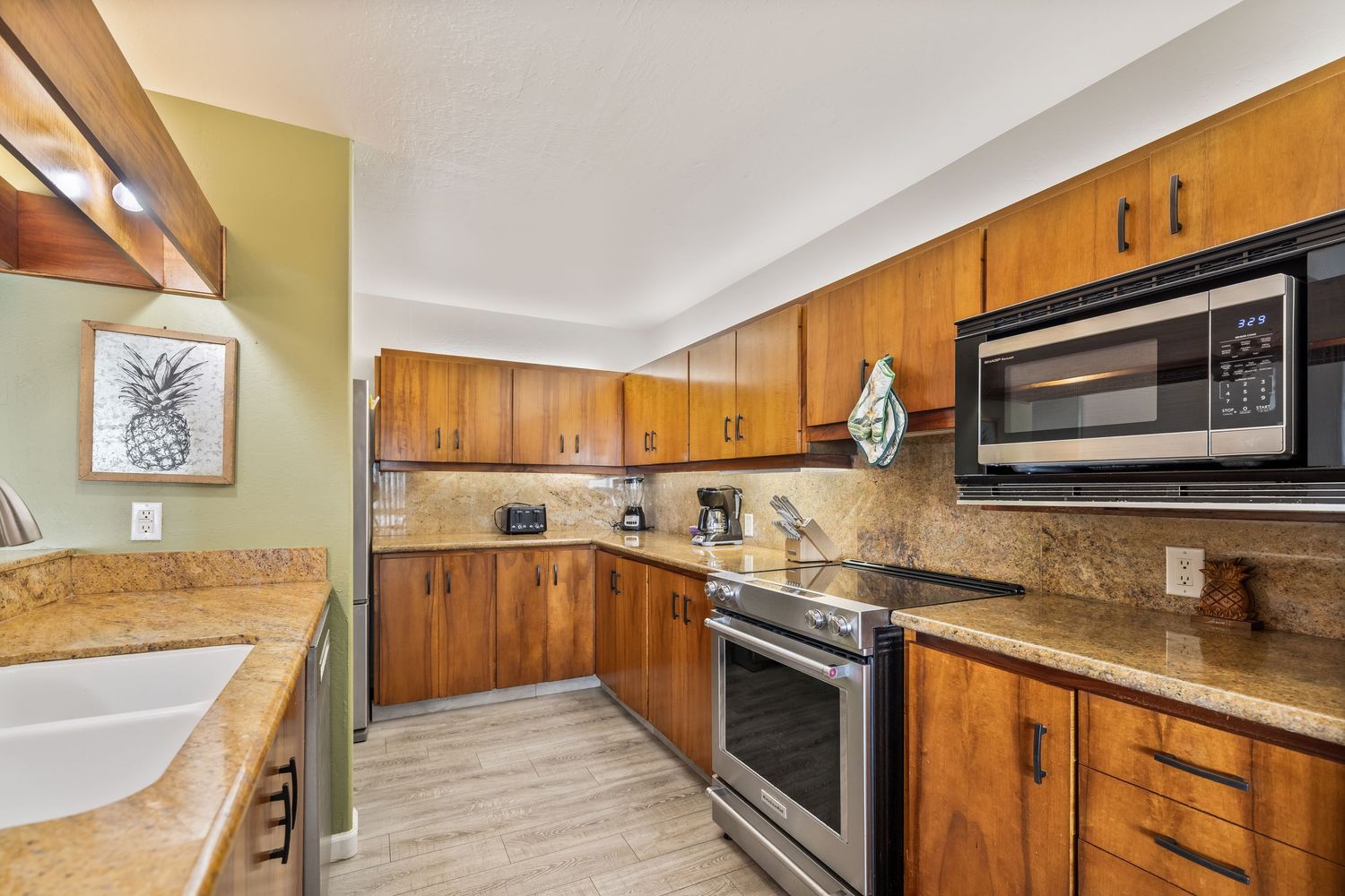 Modern kitchen with wood cabinets, granite countertops, and stainless steel appliances.