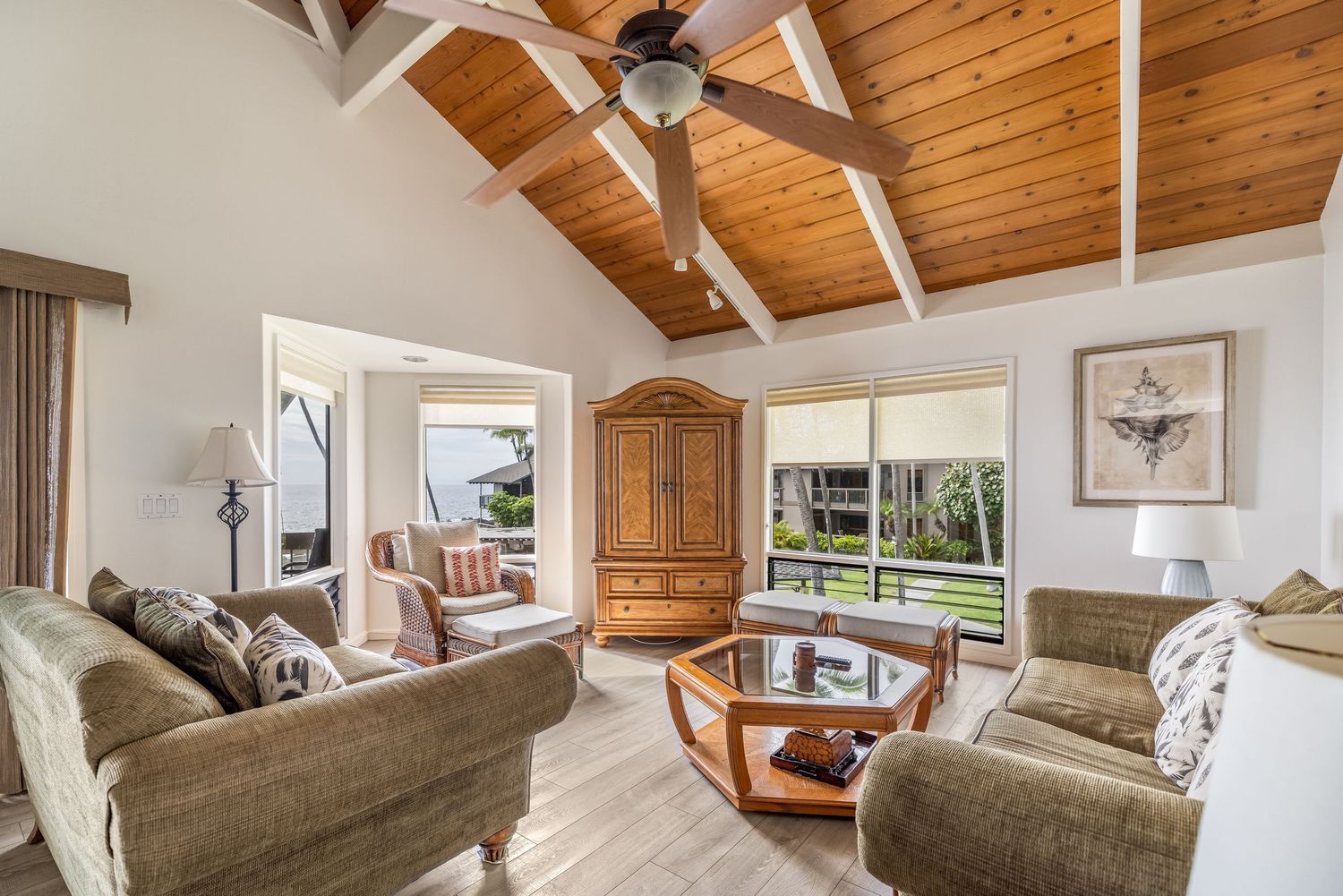 Modern living room with cathedral wood ceiling and large windows.