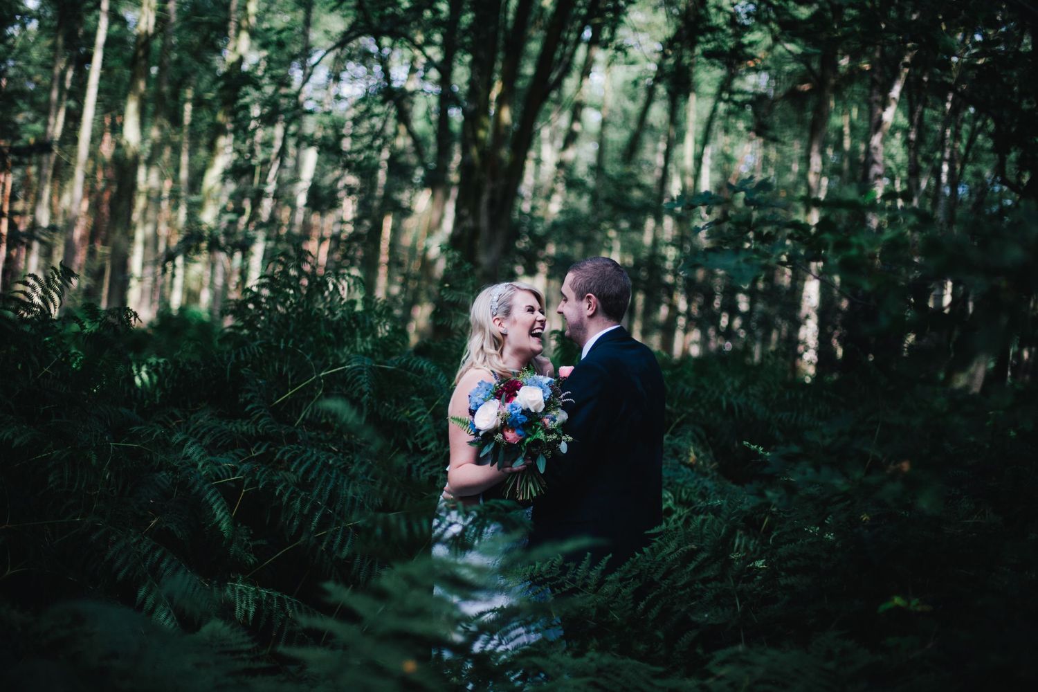 SOMERSET WEDDING PHOTOGRAPHER - Wedding portrait of a couple in the forest laughing