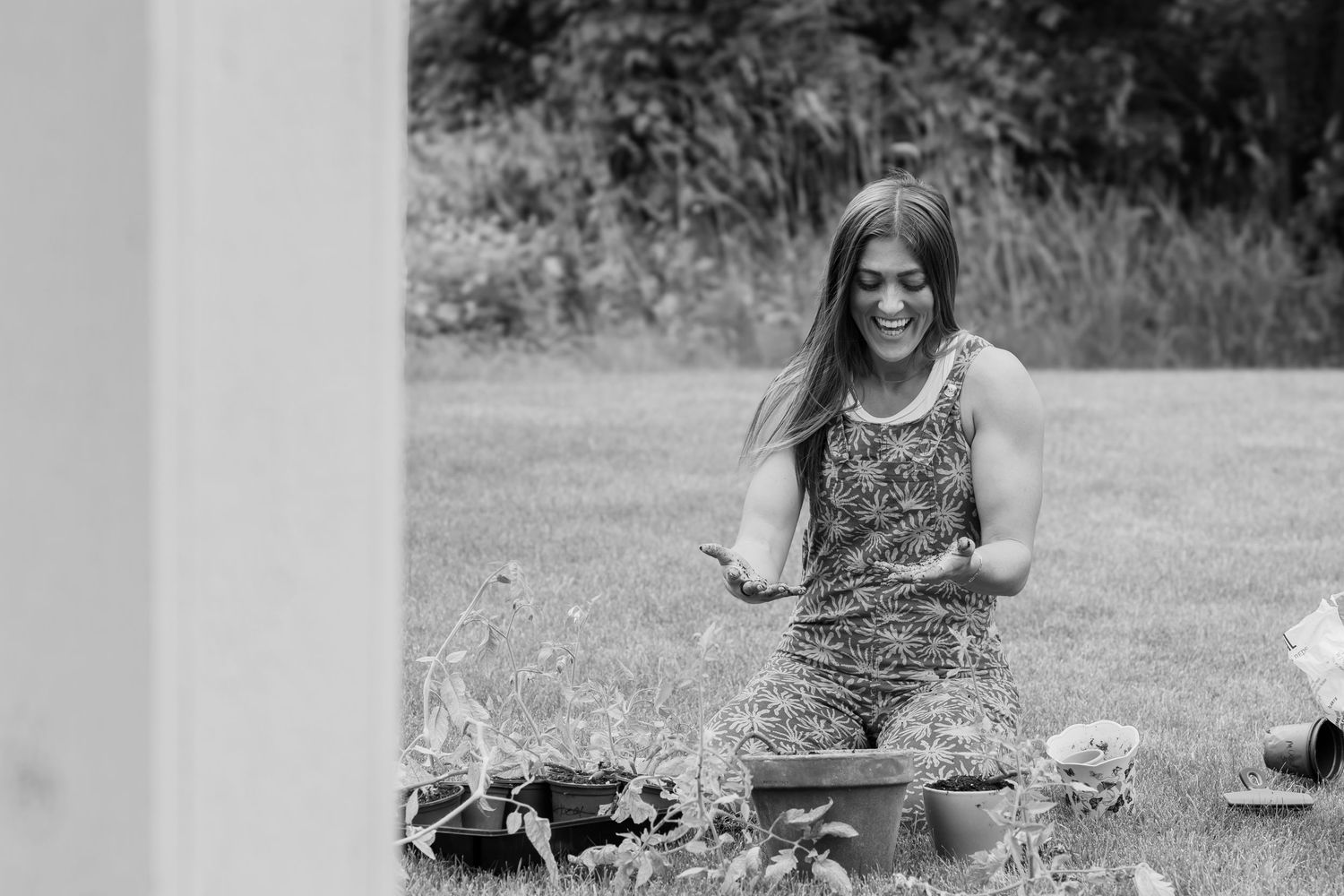Woman in animal print dress sits on picnic blanket with food spread outdoors in grassy setting.