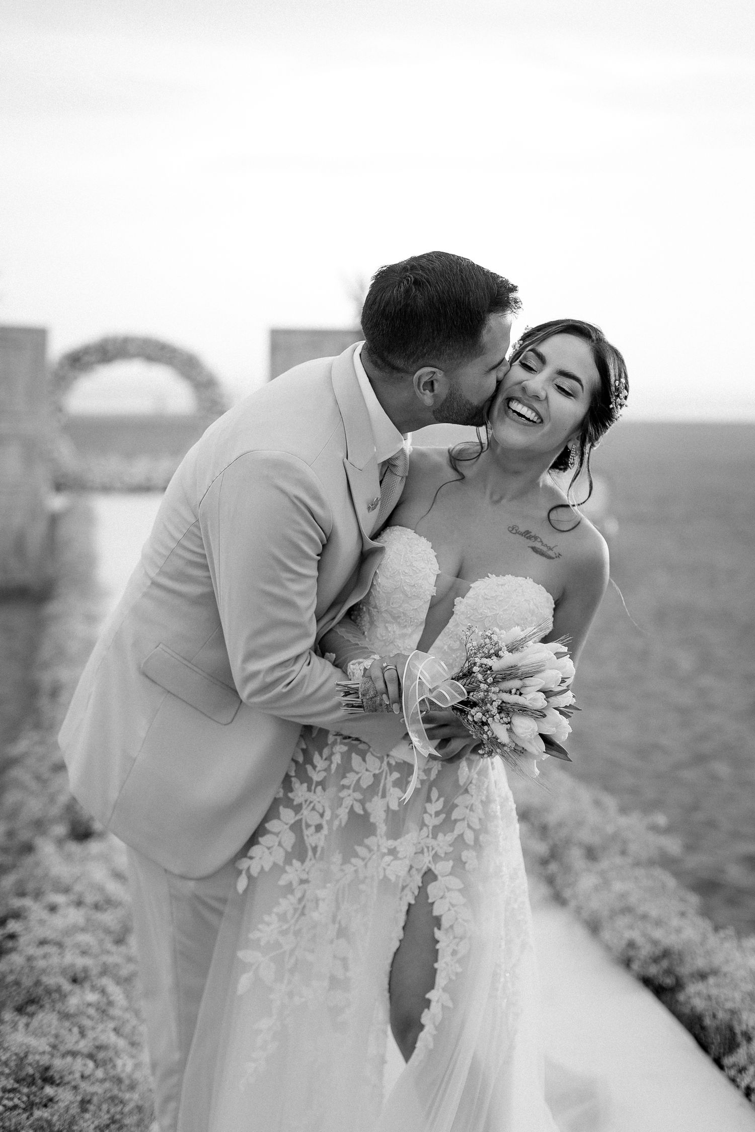 Black and white romantic wedding portrait capturing joyful moment between newlyweds.
