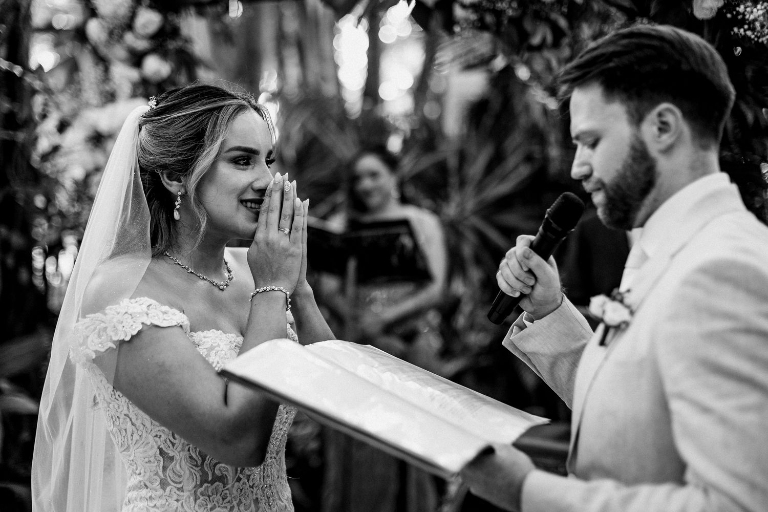 A wedding ceremony moment as couple exchanges vows with emotional expressions in an outdoor setting.