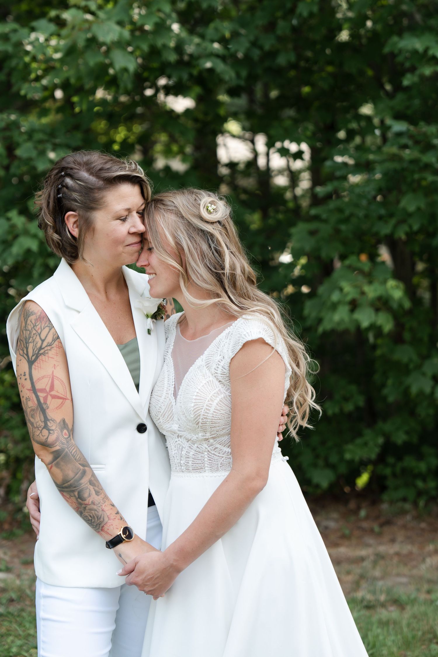 Two brides embracing at a Saco, Maine backyard wedding