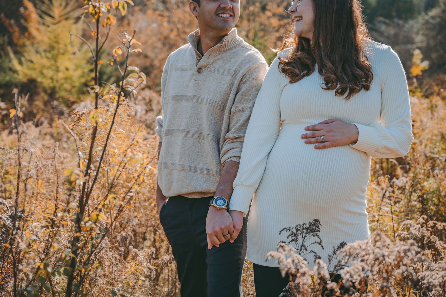 Sweet engagement photoshoot in a golden field during sunset with natural autumn colors.
