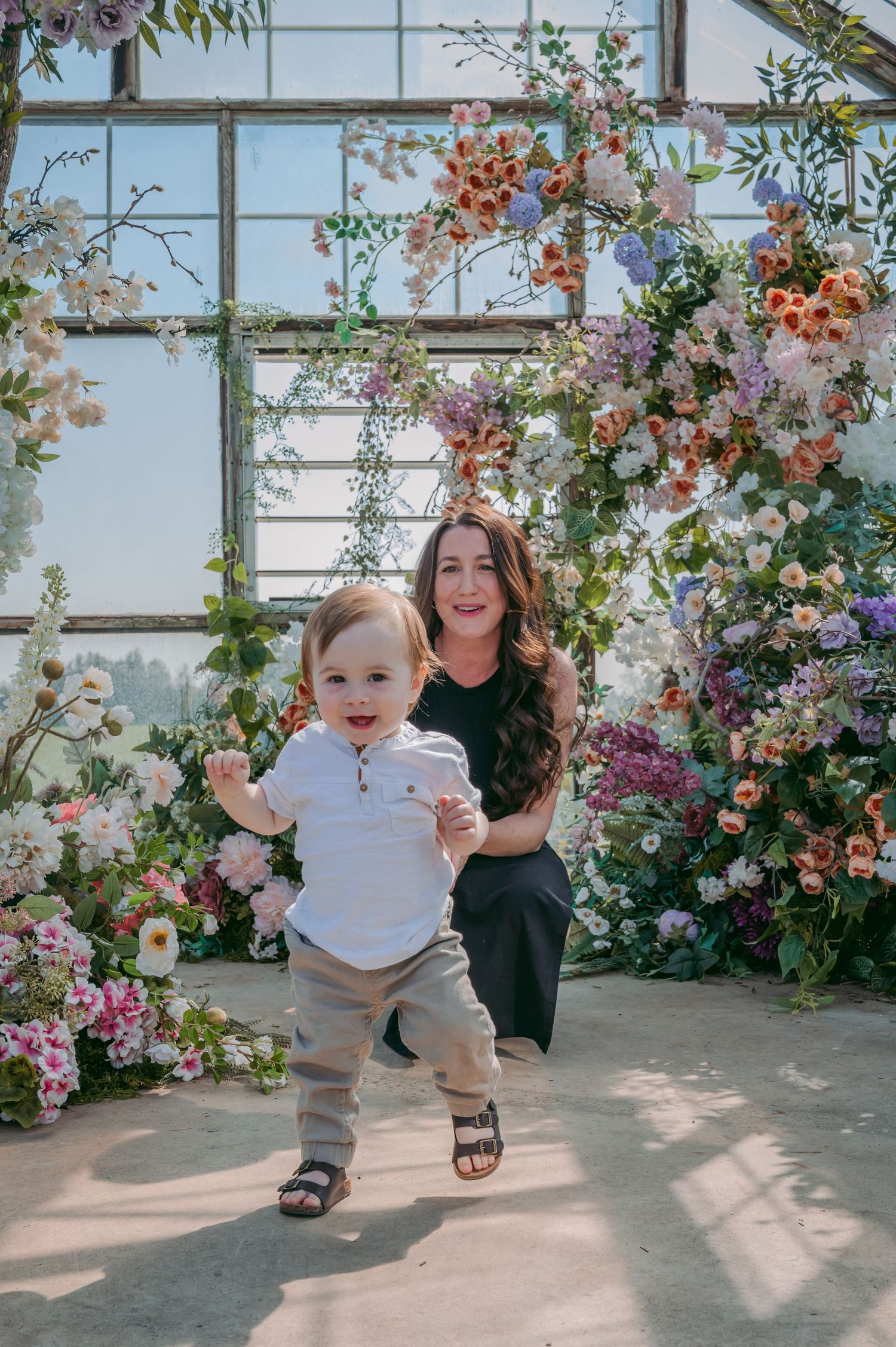 A joyful scene in a greenhouse filled with colorful climbing flowers and natural light.