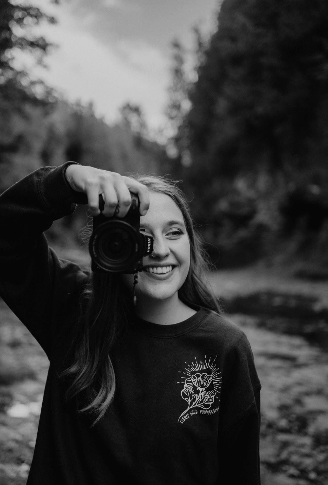 Black and white portraits of someone holding a camera outdoors.