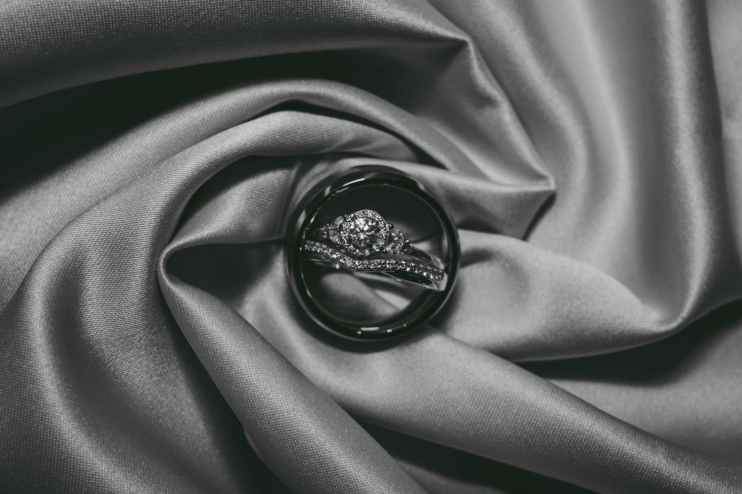 Close-up of smooth gray silk fabric with elegant folds and shadows.