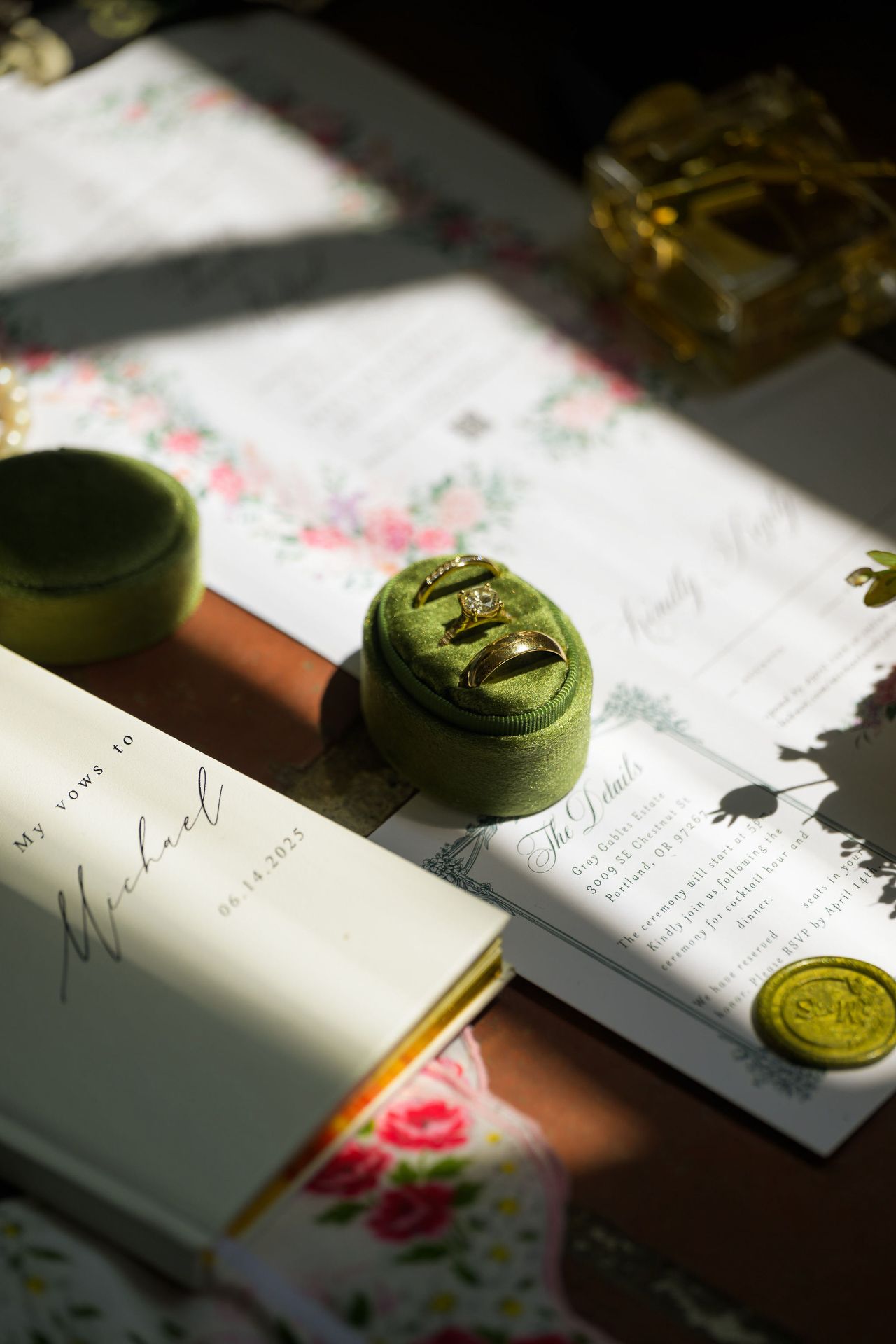 Wedding invitation and green wax seals photographed in dramatic natural light.
