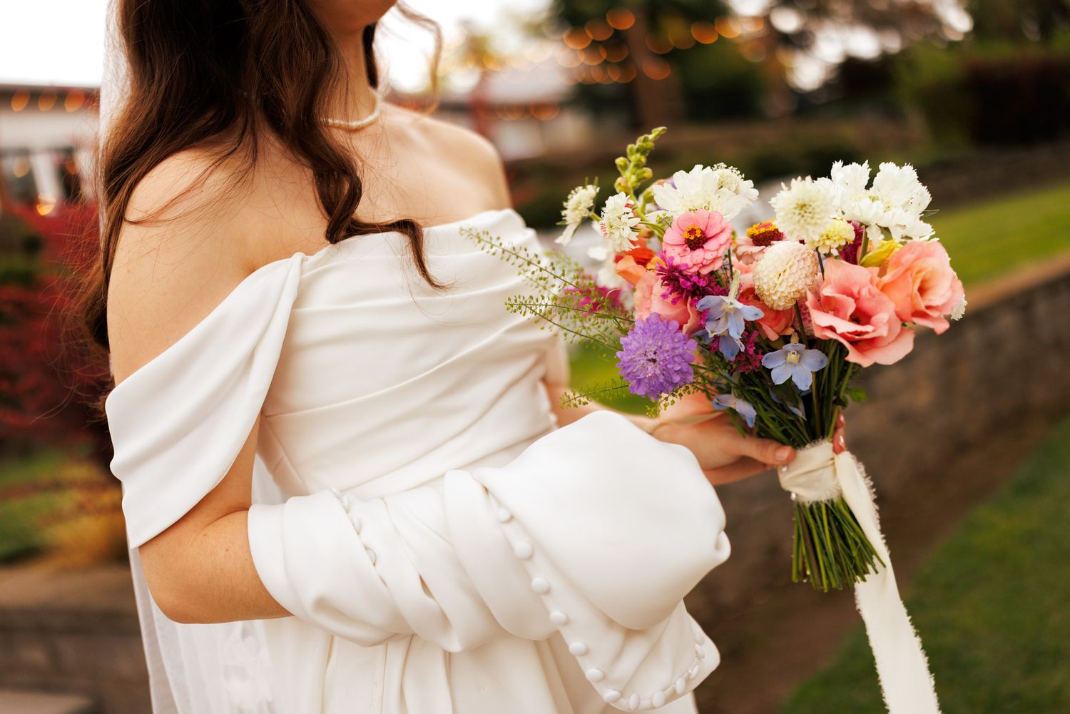 Bride carrying her dress and colorful bouquet down the isle at Aurora Vineyards in Oregon Wine Country