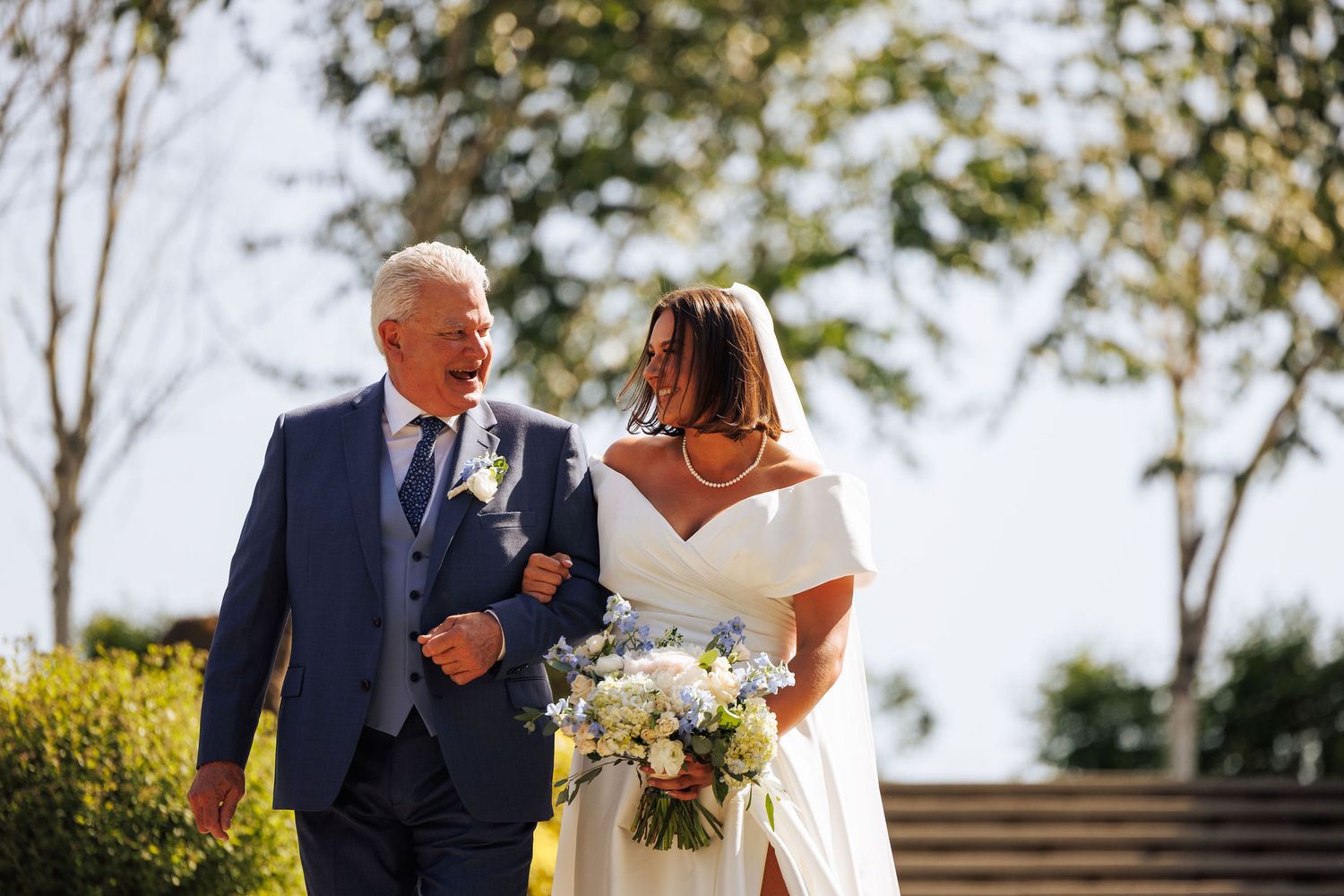 Couple walking through vineyard during golden hour wedding photoshoot.