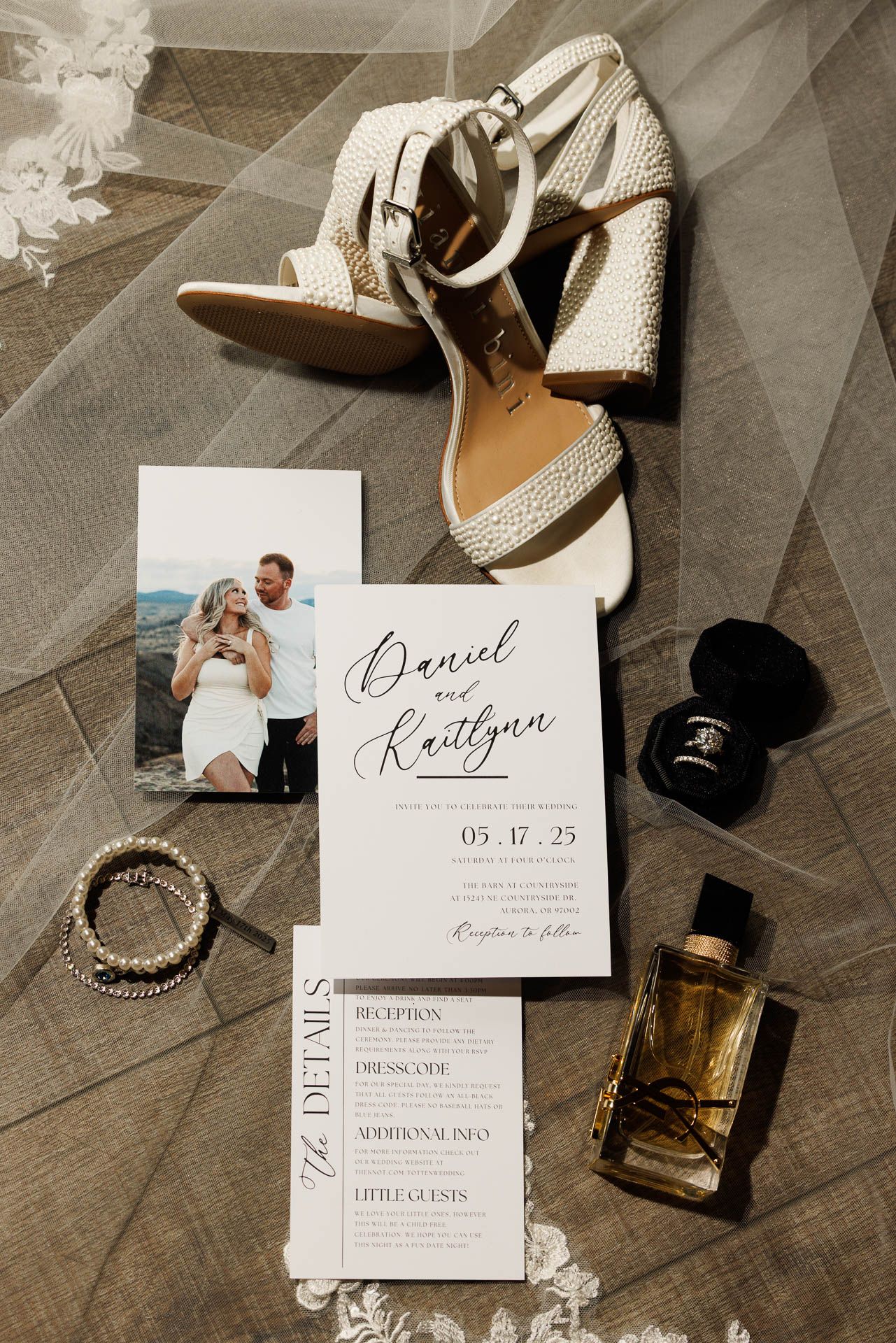 Wedding details flatlay with invitation, shoes, perfume and jewelry.