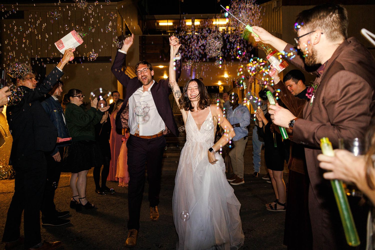Wedding guests celebrate with sparklers during an evening reception.