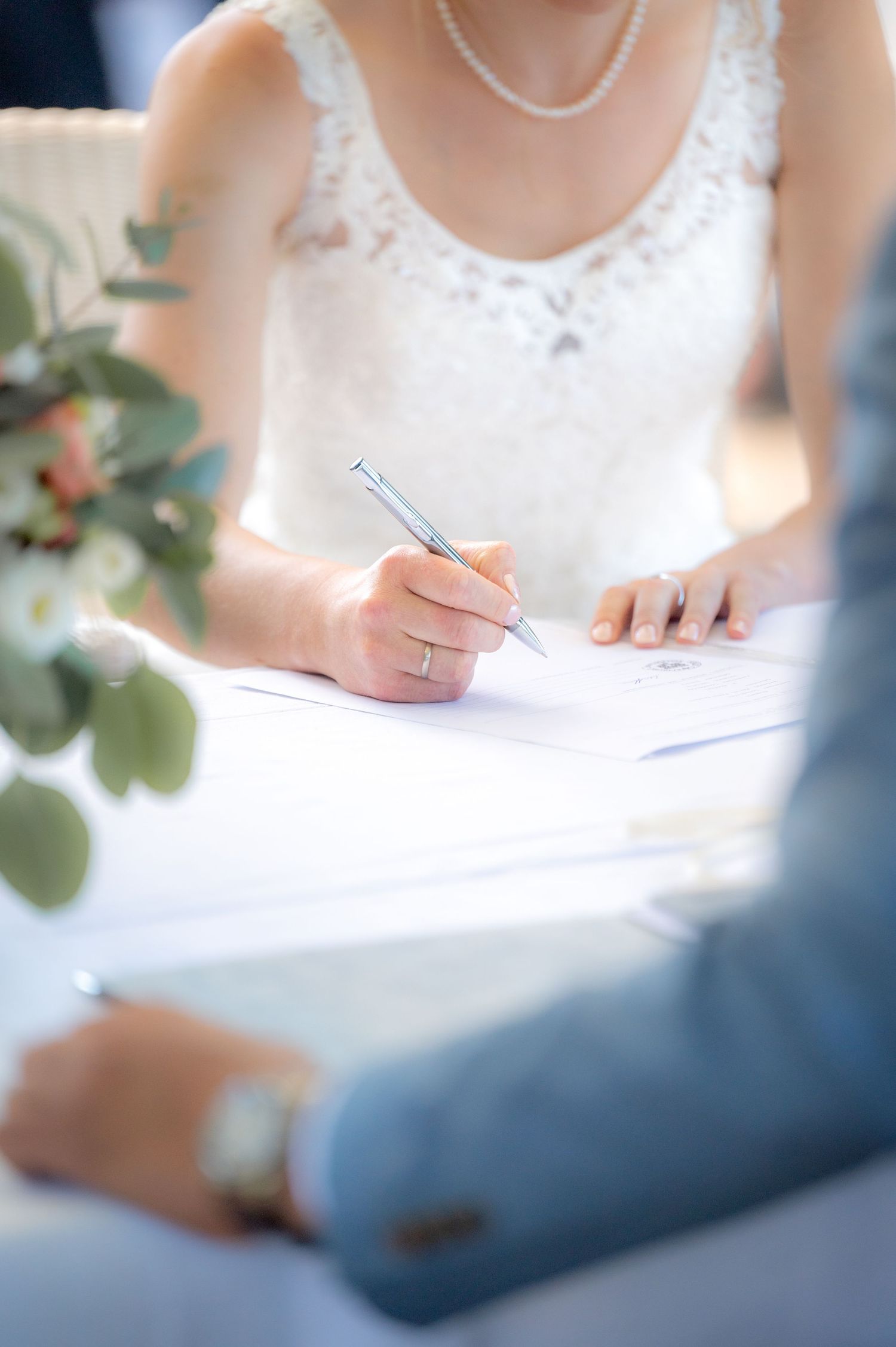 Detailaufnahme der Braut biem unterschreibendes Heiratsurkunde