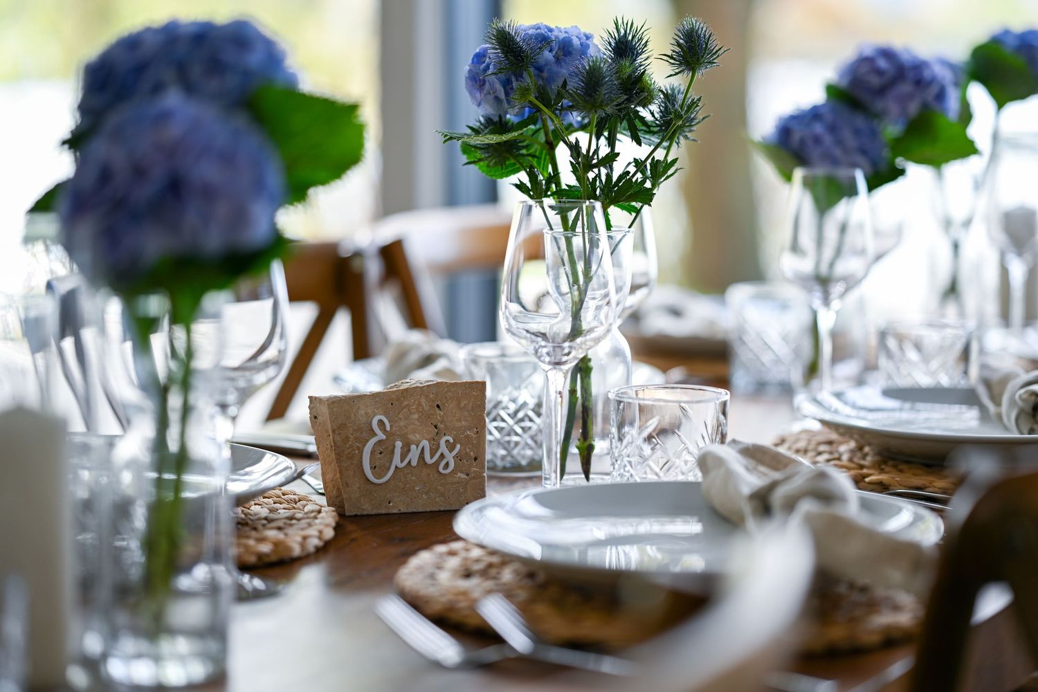 Foto von einem Hochzeitstisch, eingedeckt, lila Blumen, Gläser