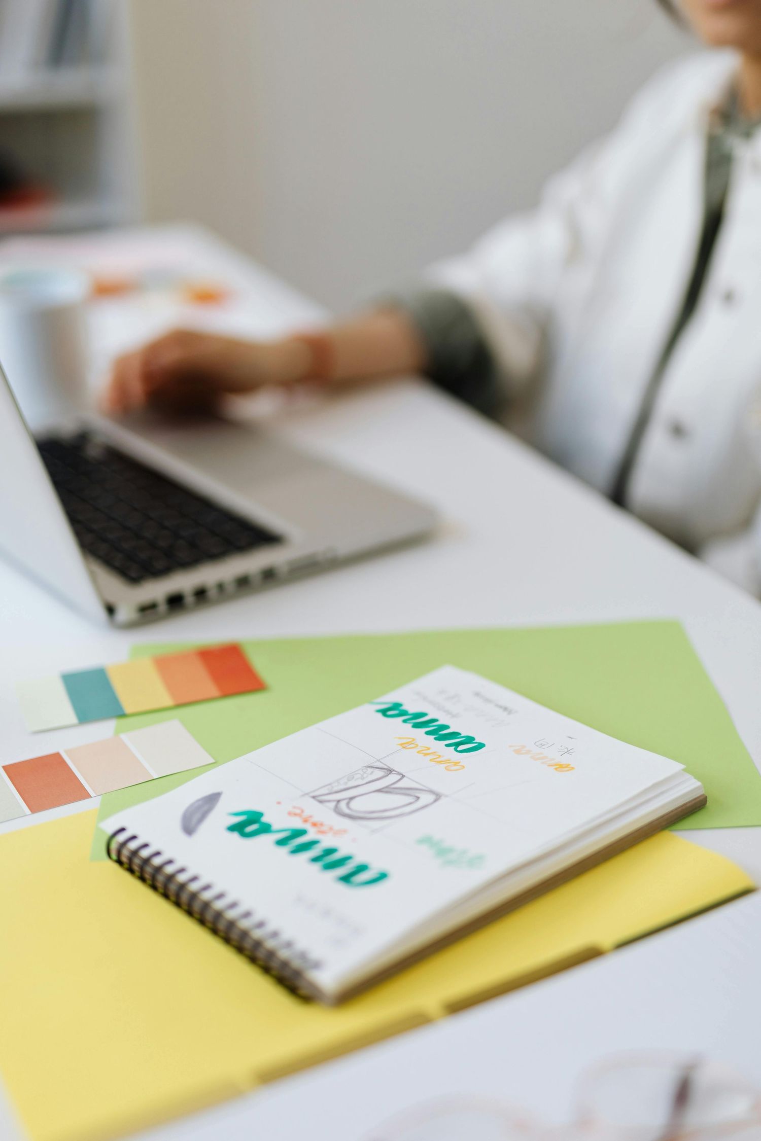 Branding workspace flatlay with laptop, color palette swatches, and sketches—creative direction and visual strategy at Dolce Vita Studio.