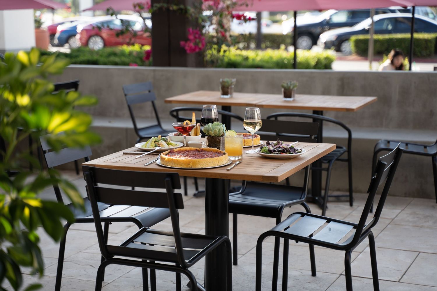 Cozy al fresco dining setup with deep dish pizza and fresh salad under string lights on restaurant patio