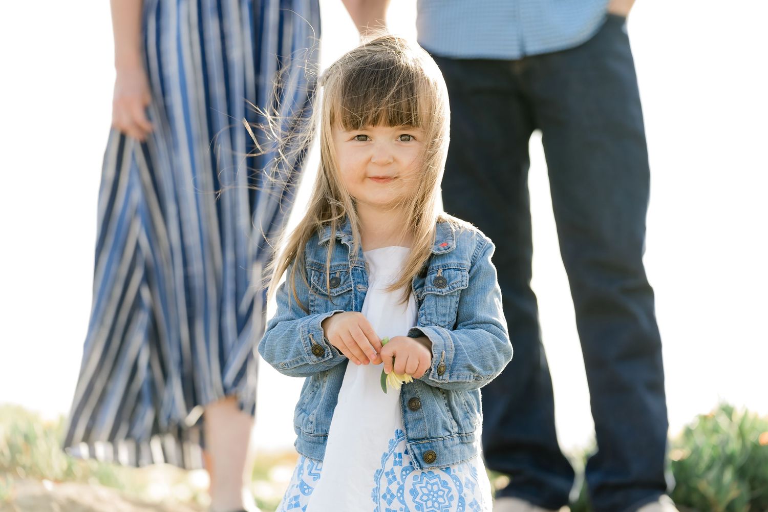 Candid family moment with child running toward the photographer – natural light photography on Southern California coast