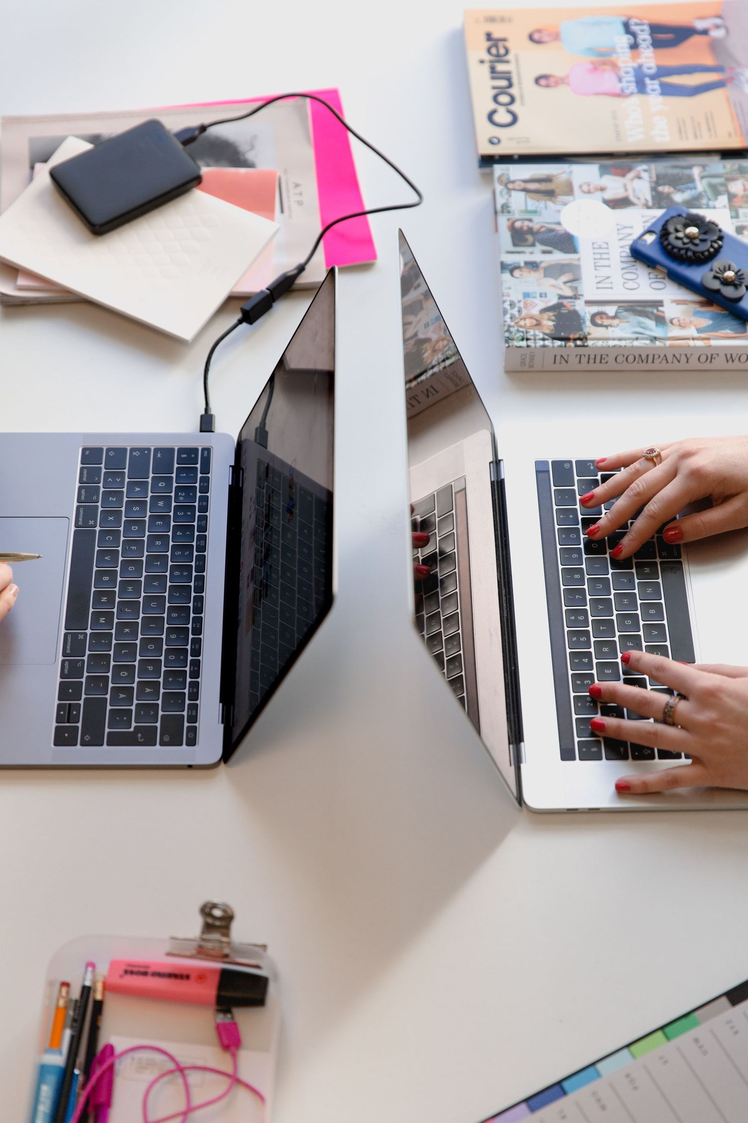 Back-to-back laptop users focused on individual tasks in a collaborative setting