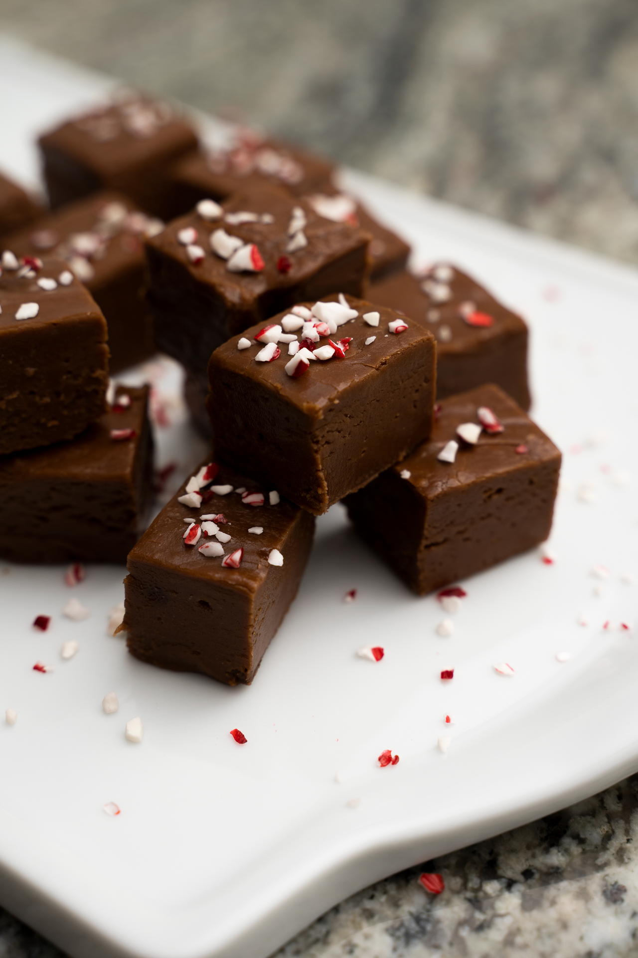 indulgent fudge squares topped with peppermint and stacked with a marble backdrop – small-batch dessert for food photography portfolio