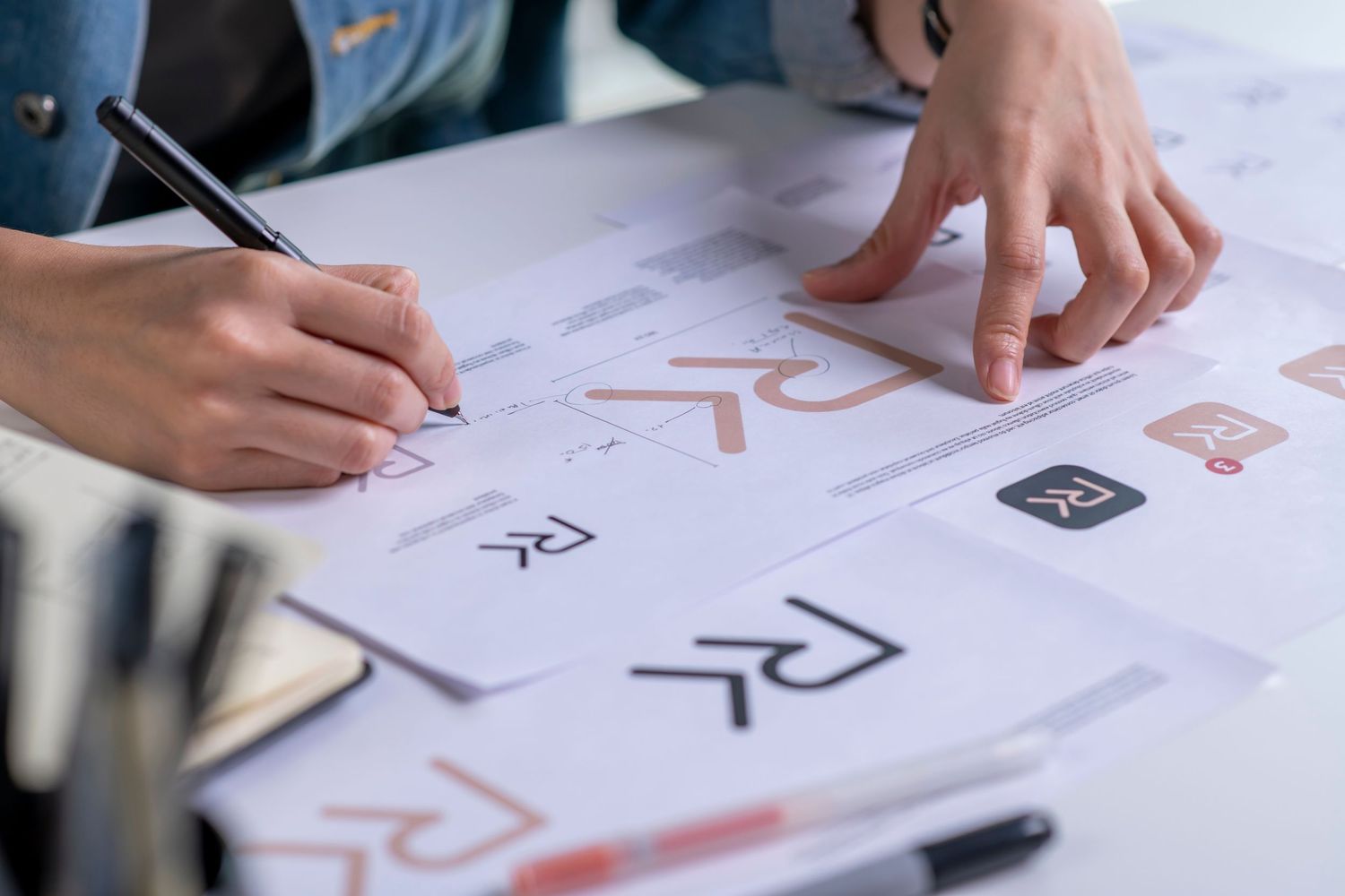 Designer’s hands reviewing brand style guide—San Diego visual identity and logo design process at Dolce Vita Studio.