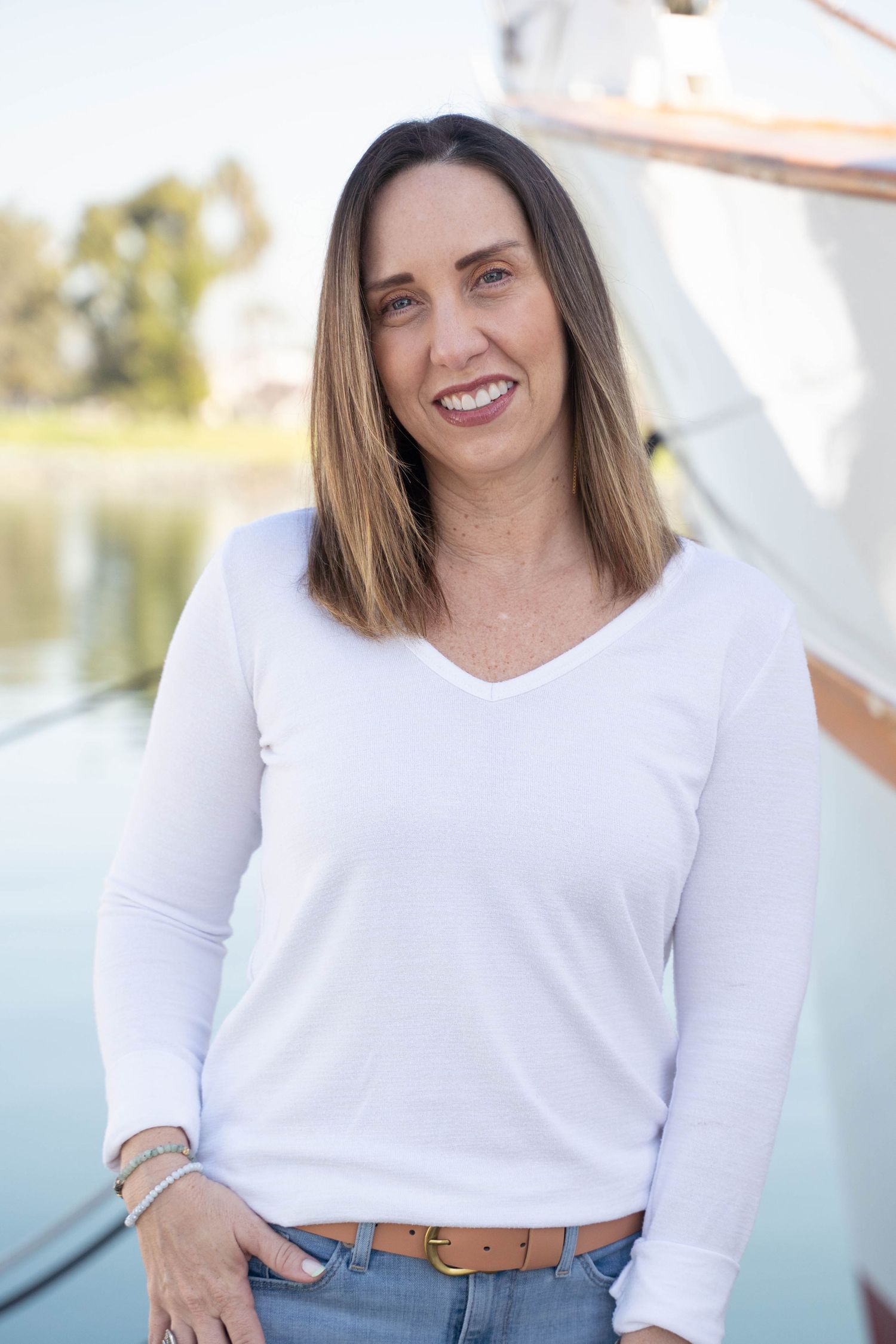 Outdoor headshot with sea breeze and sunlit coastal scenery – fresh personal branding photo