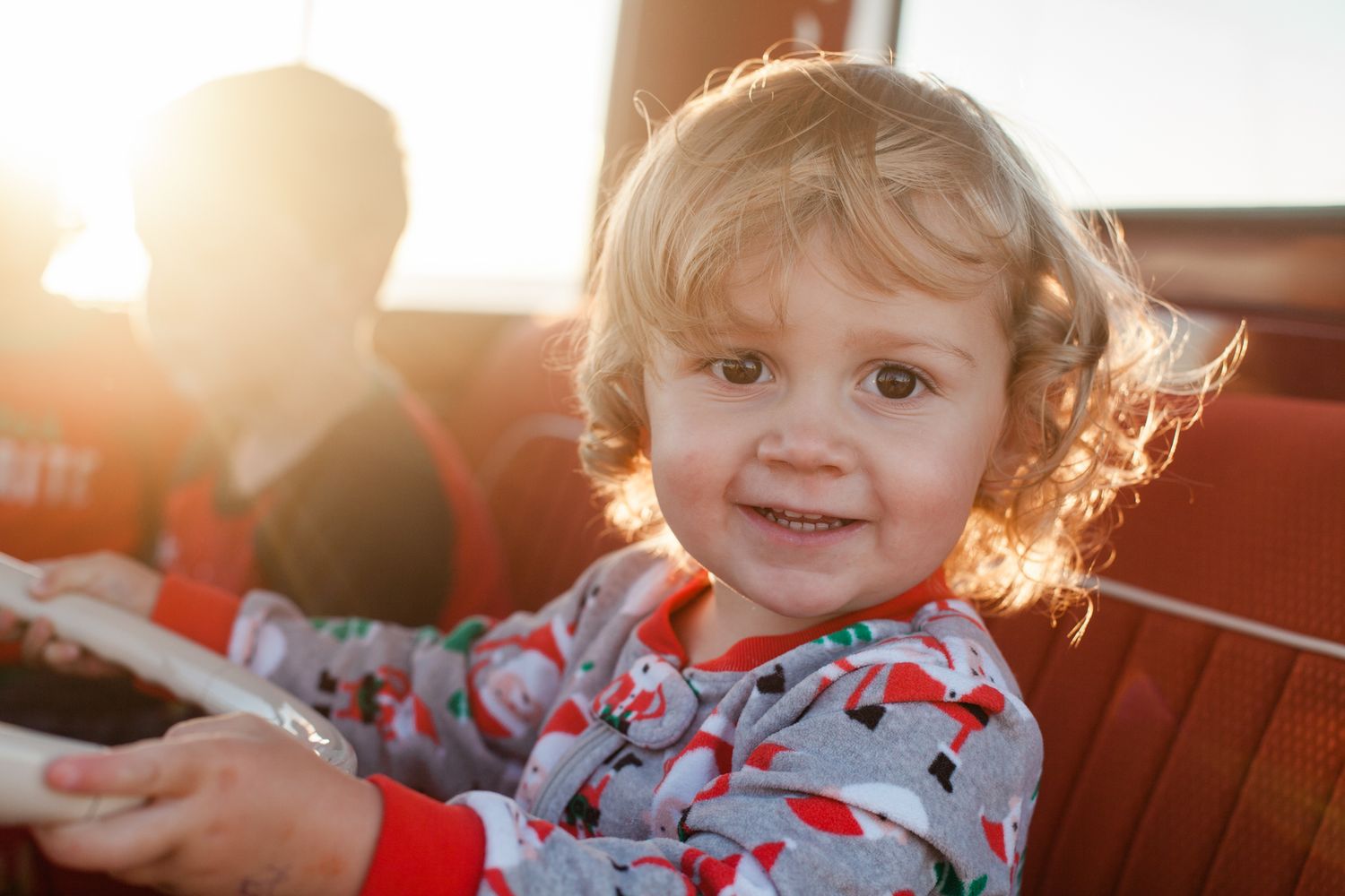 a feisty little boy plays at the steering wheel of a vintage VW bus
