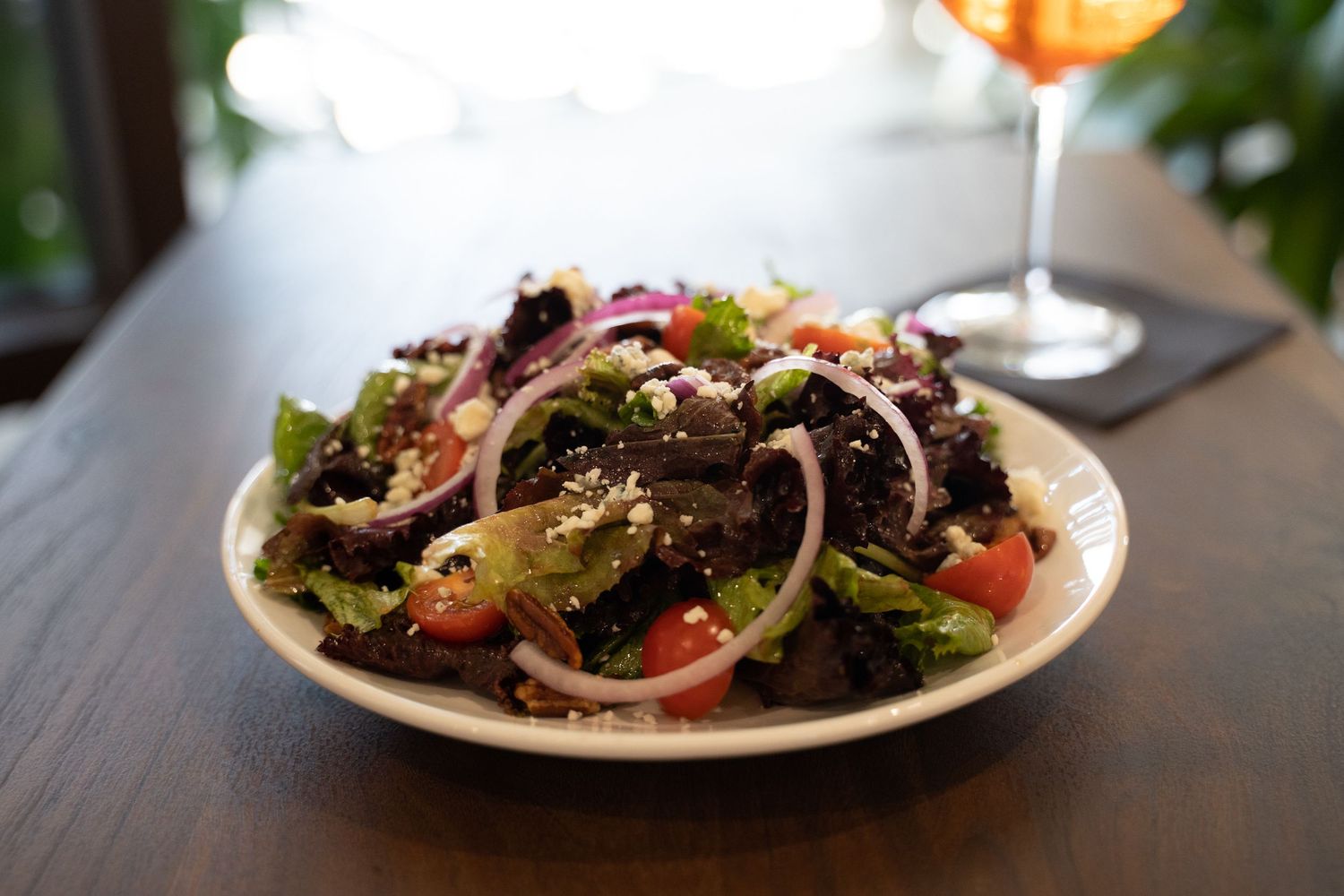 a mediteranean salad paired with an aperol spritz