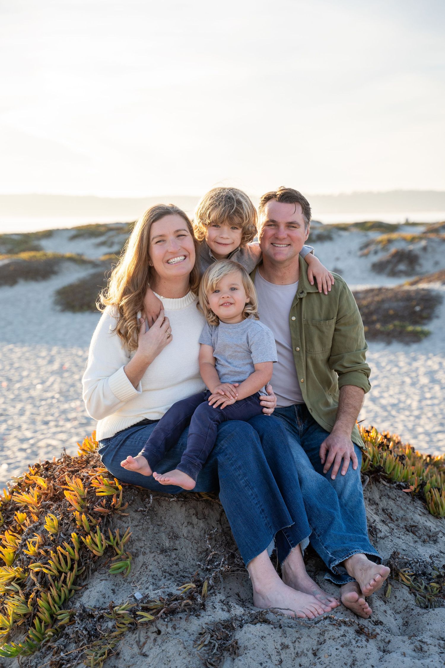 Playful family of four with ocean breeze and pastel sunset sky – Coronado lifestyle photo shoot