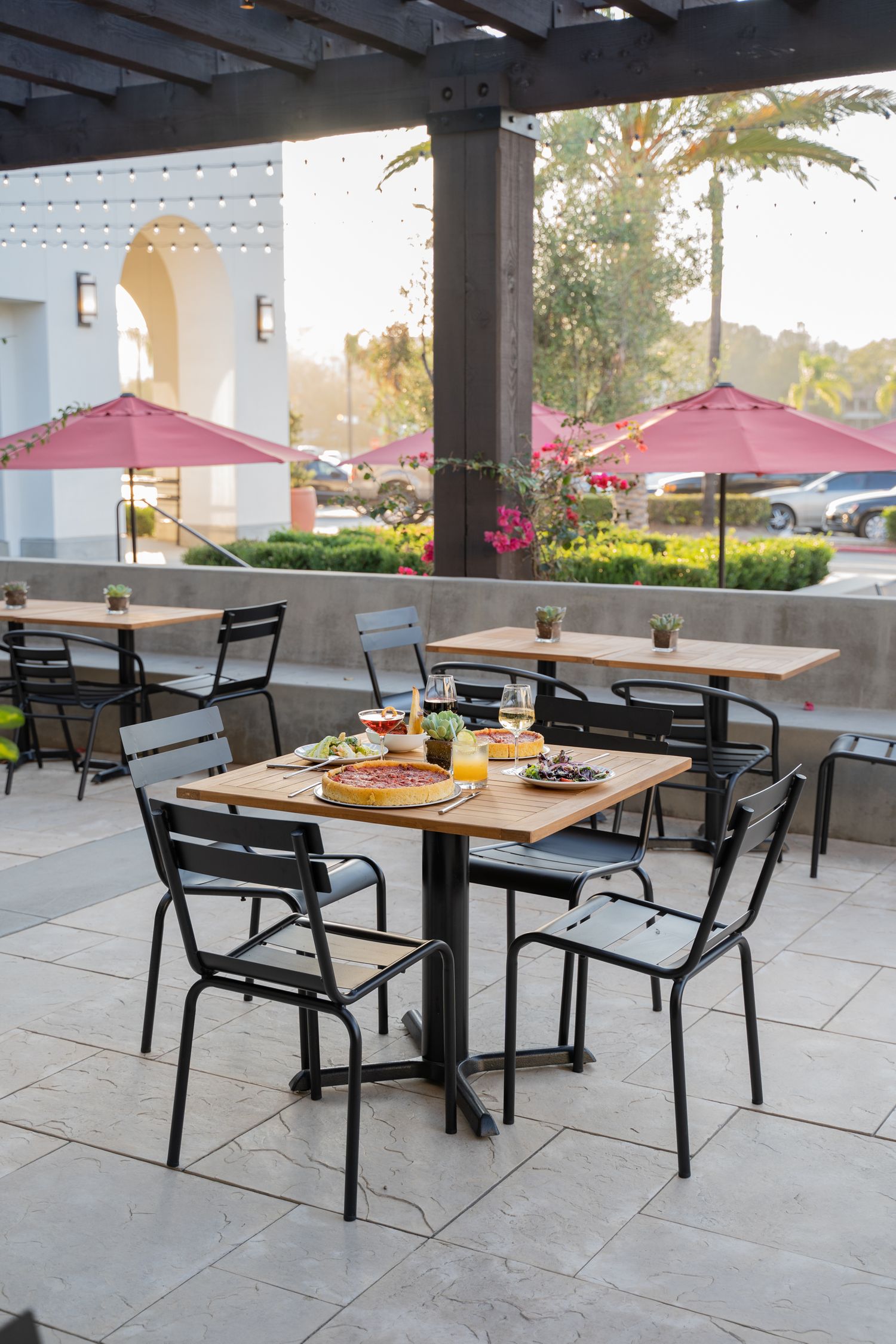 Evening photo of twinkle-lit patio at neighborhood pizzeria – inviting space for outdoor dining