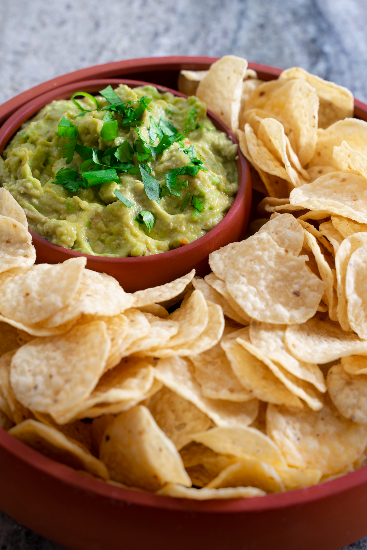 Close-up of creamy guacamole with golden tortilla chips – photographed for a farm-to-table cookbook
