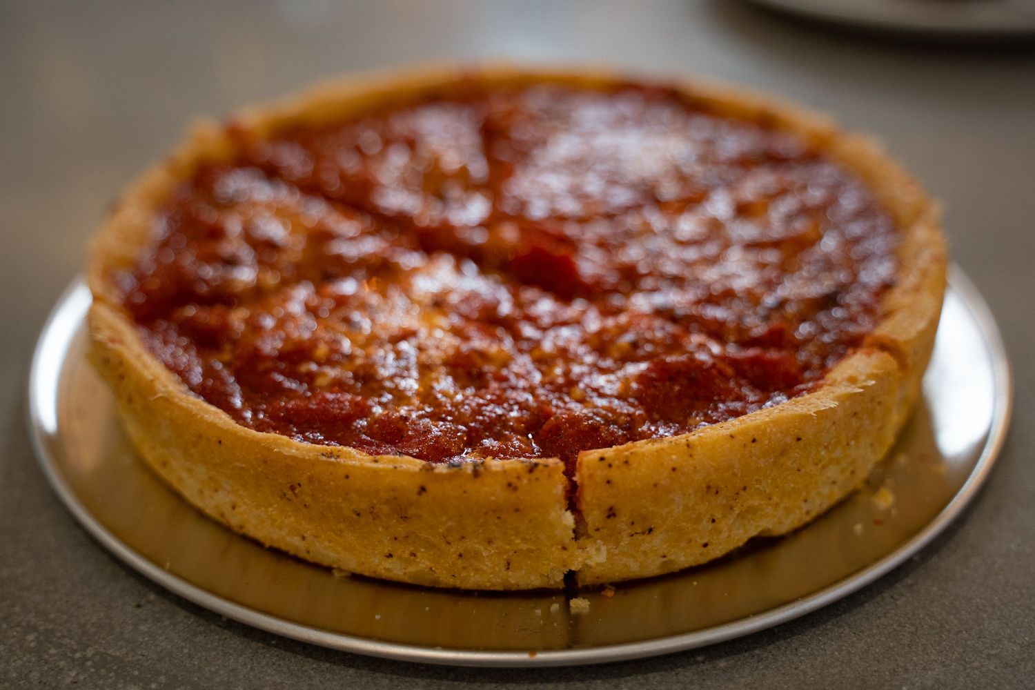 Freshly baked deep dish pizza – hearty, rustic dinner as served at The Shop Pizzeria
