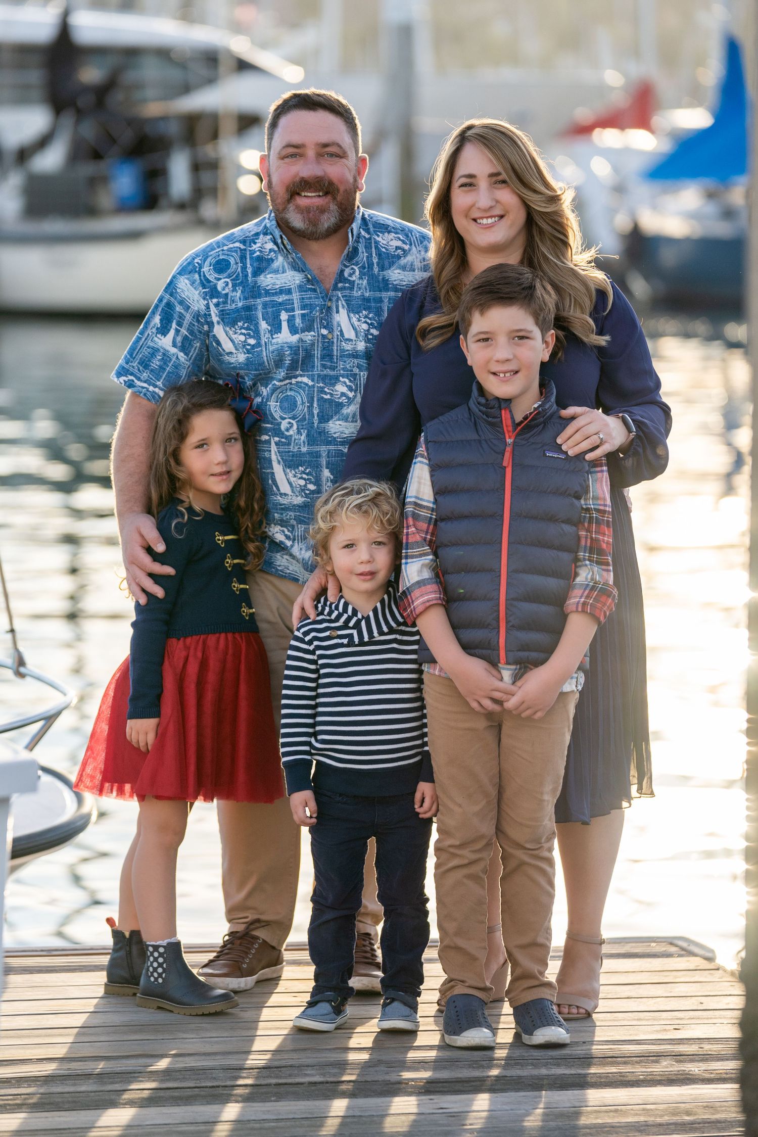 Smiling family of five with nautical background and sailboat masts – Southern California yacht club session