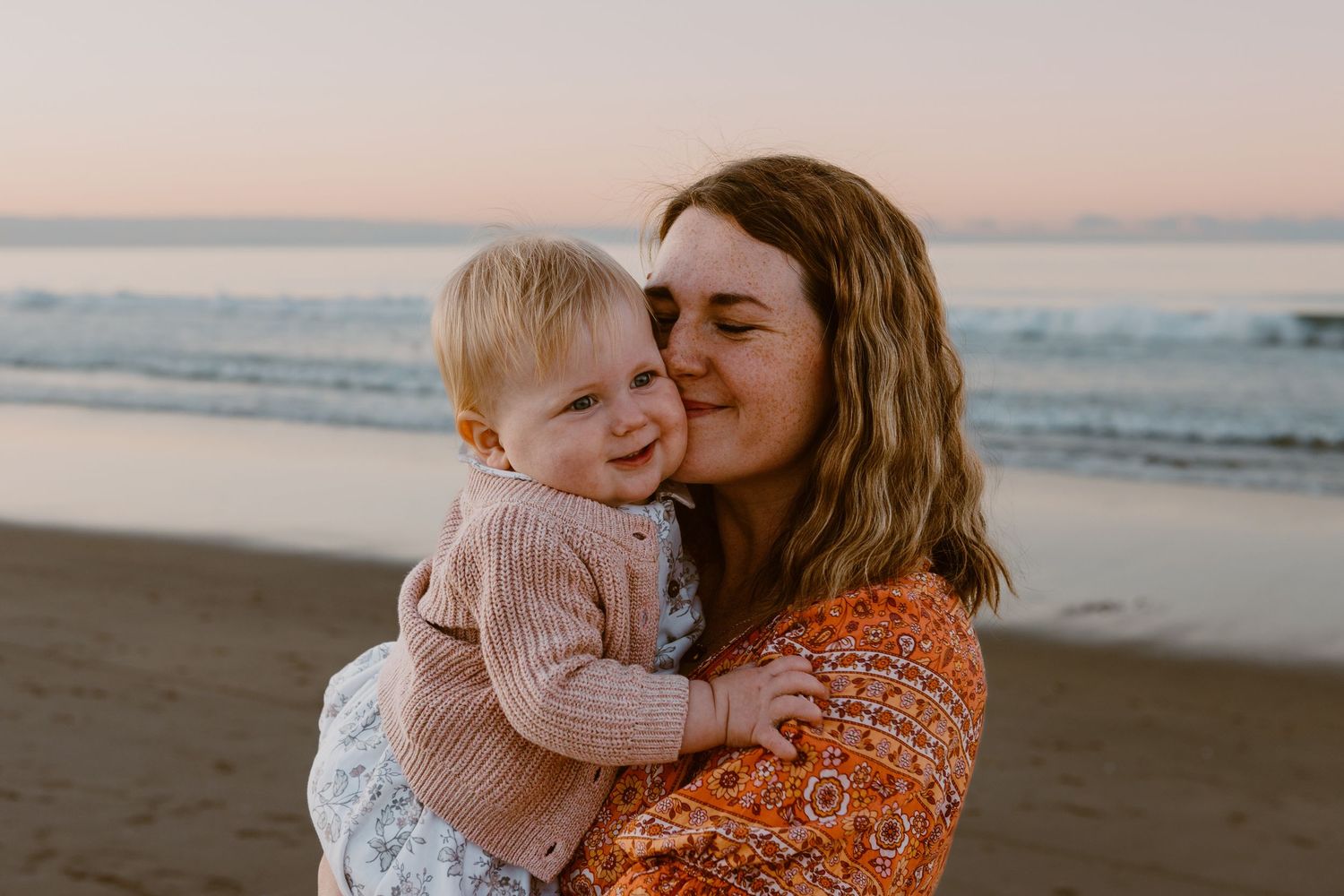 Sweet candid moment captured during sunset beach photoshoot.