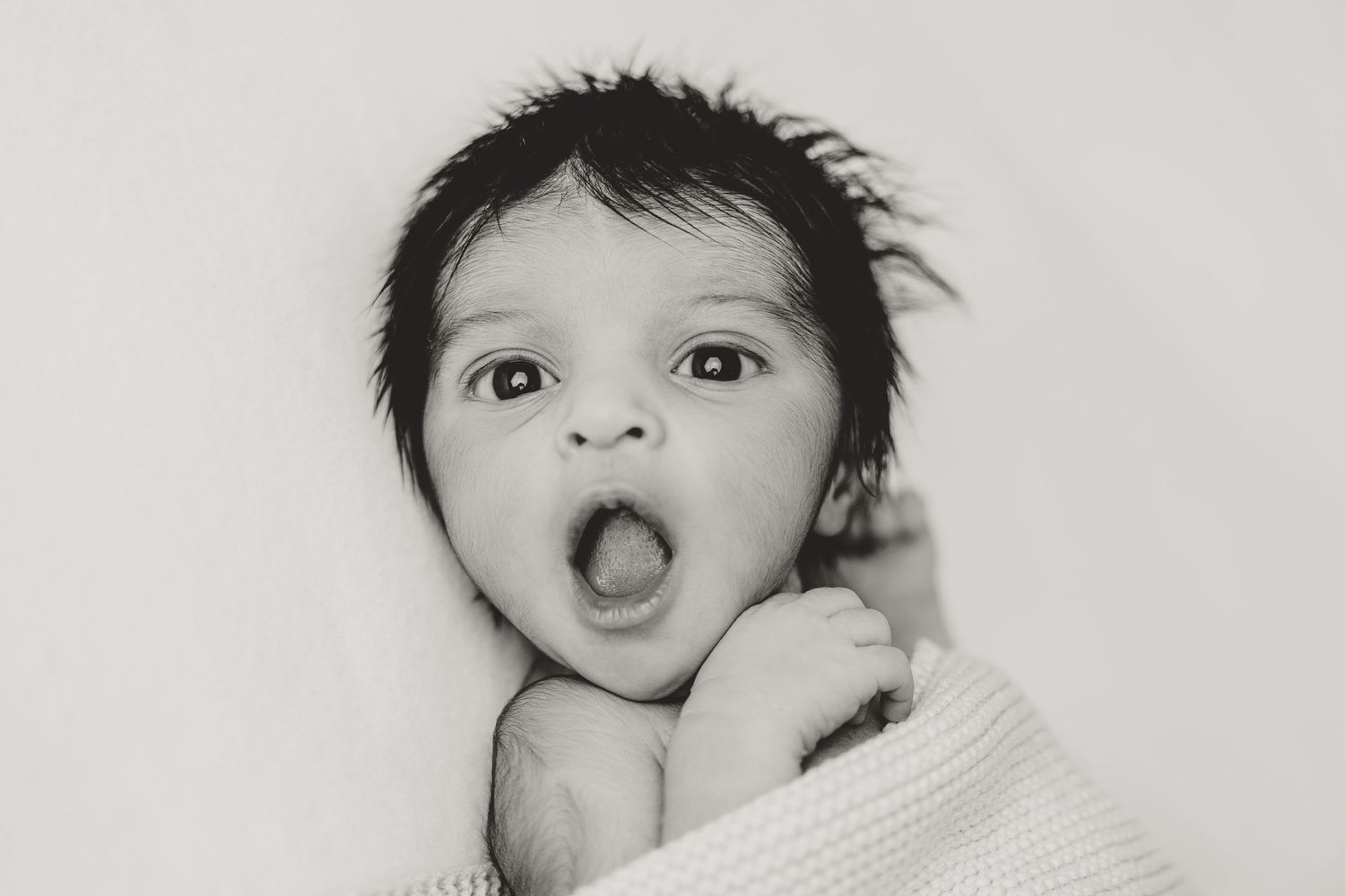Series of playful expressions of a baby against light background.