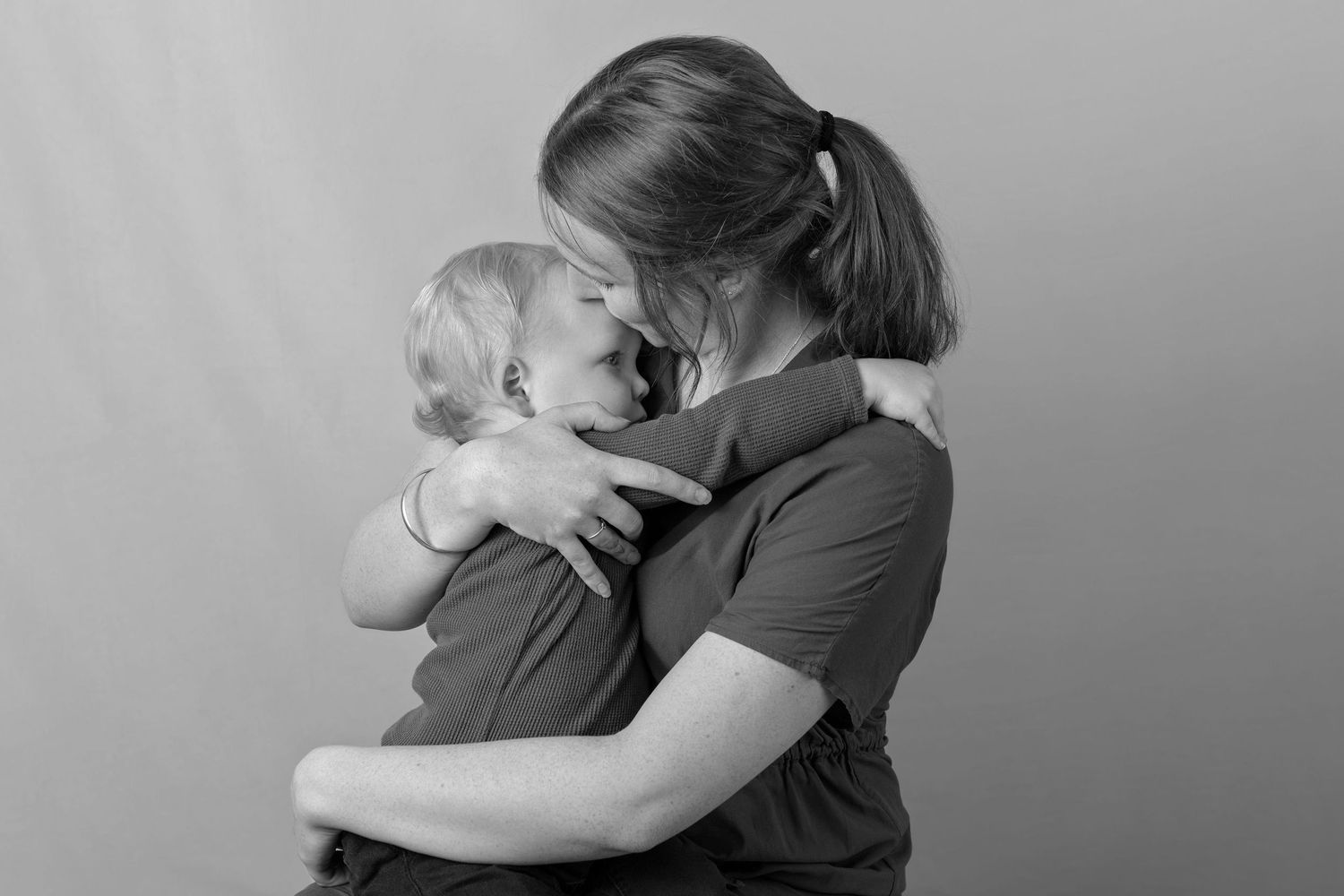 A tender embrace captured in black and white between parent and child.