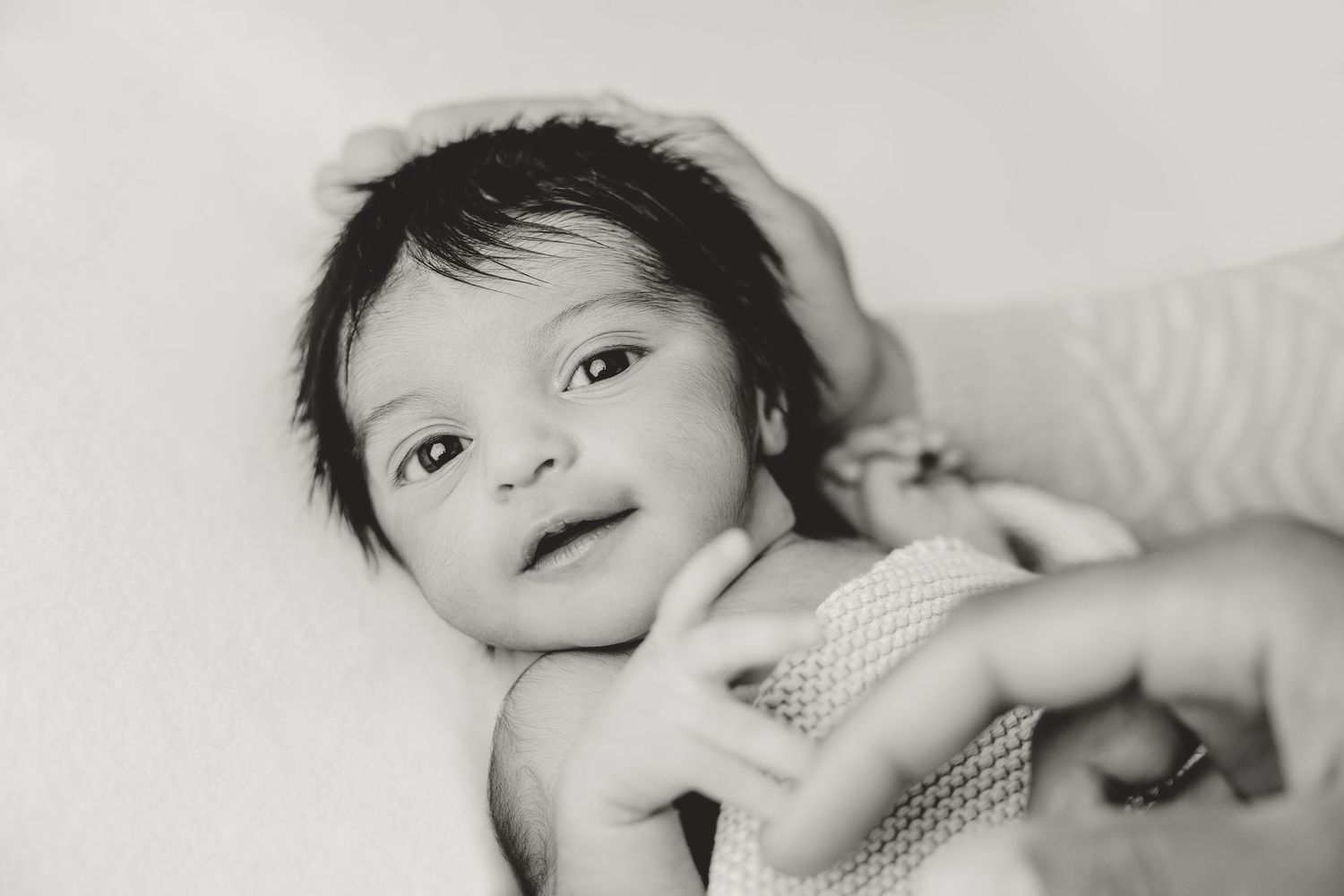 Newborn photography series showing different facial expressions on white backdrop.