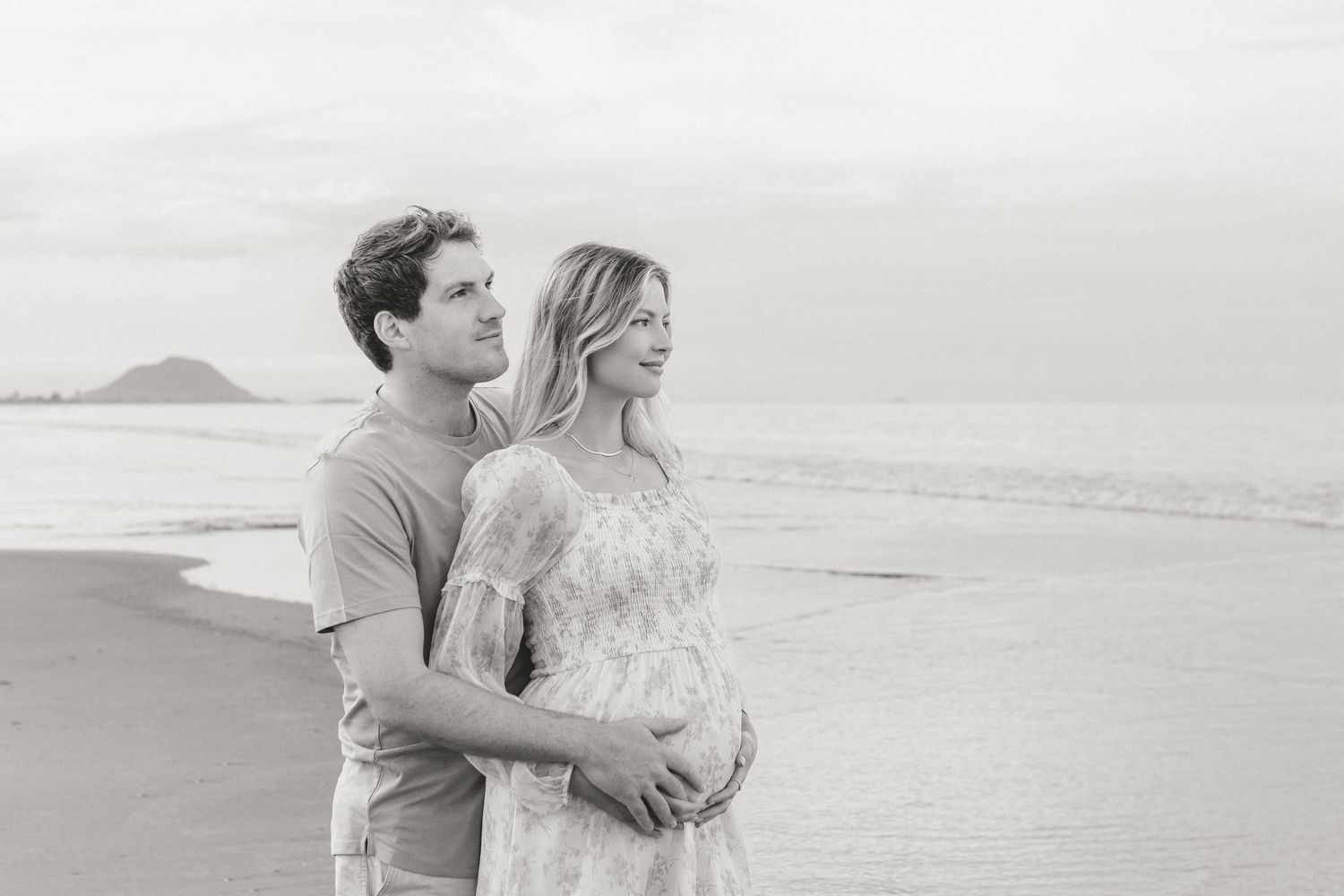 A romantic coastal maternity photo shoot on a misty beach in black and white.
