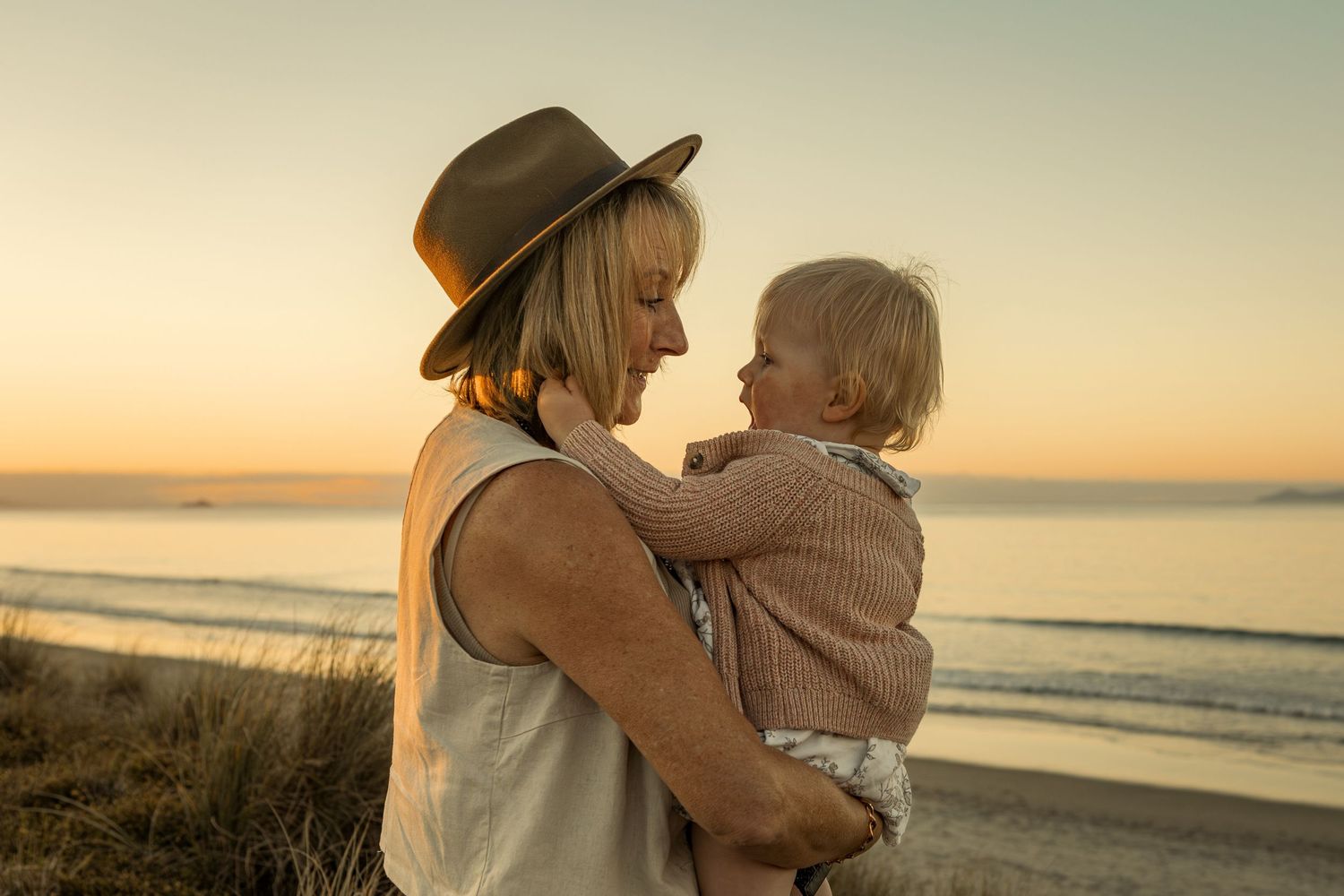 A warm sunset moment shared between parent and child on the beach.