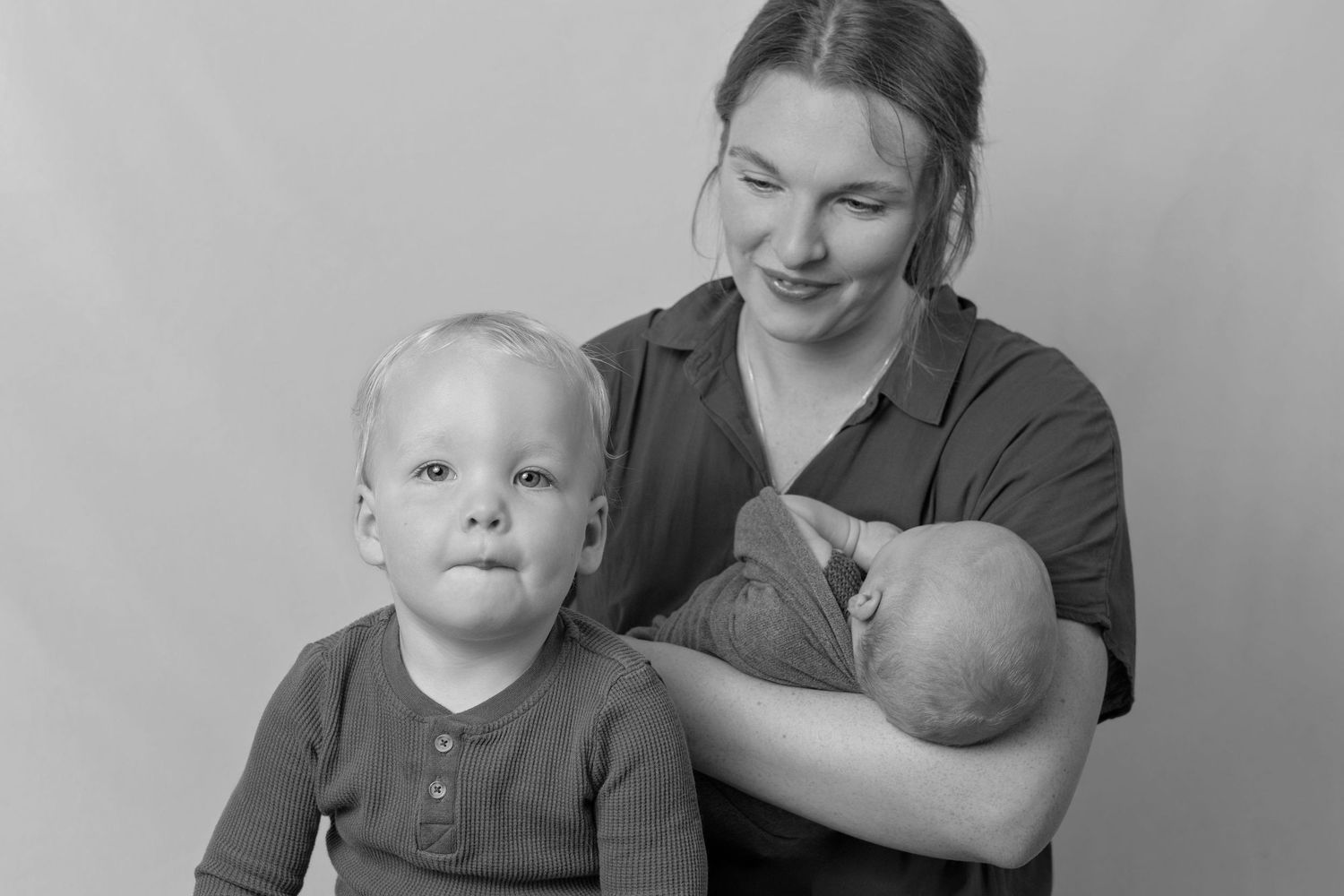 A family portrait in black and white showing tender moments between parent and children.