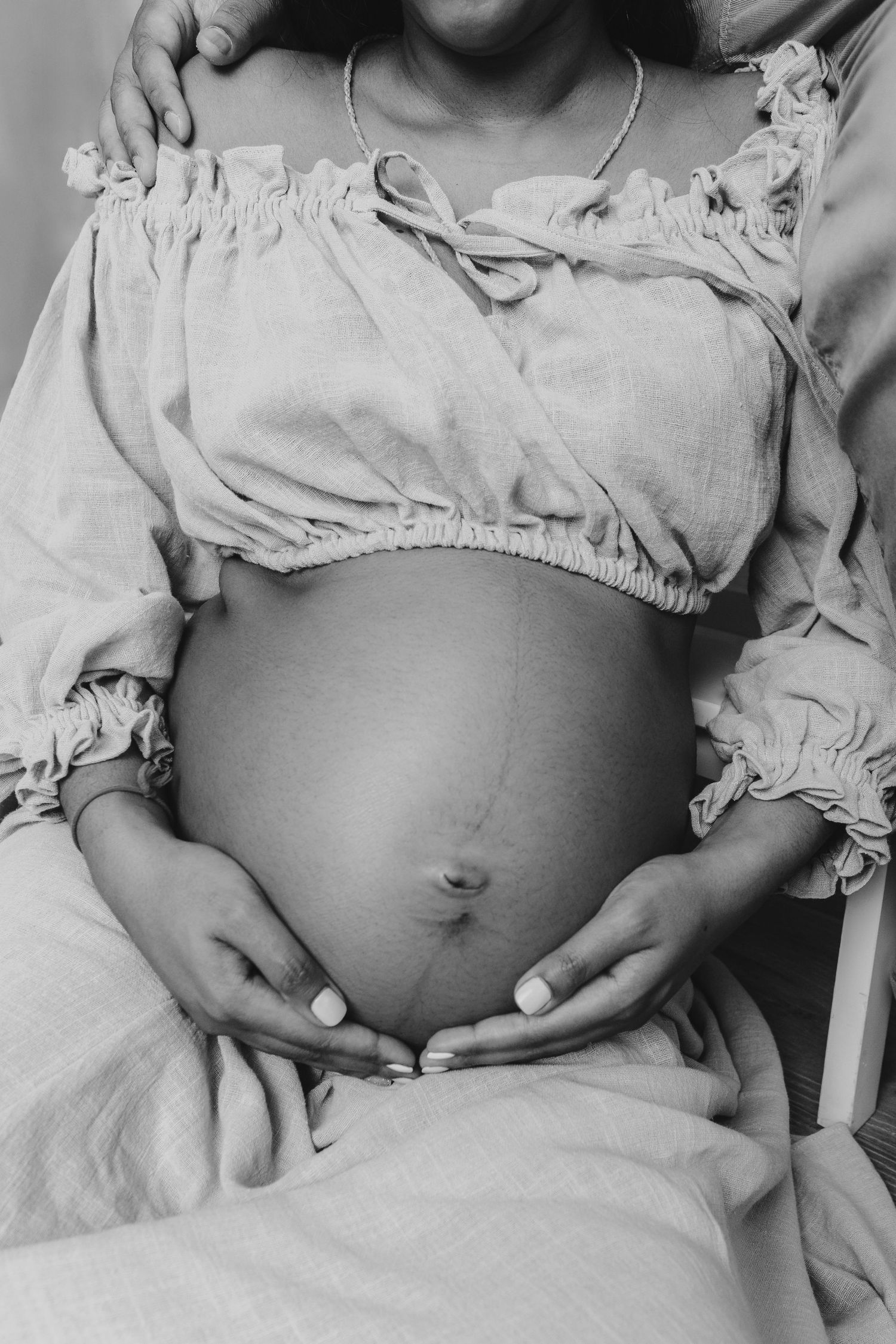Black and white close-up photos showing baby bump progression during pregnancy.