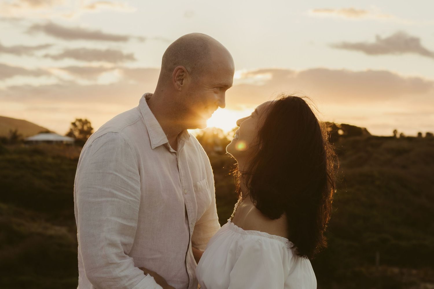 A romantic sunset silhouette of two people sharing an intimate moment against a golden sky.