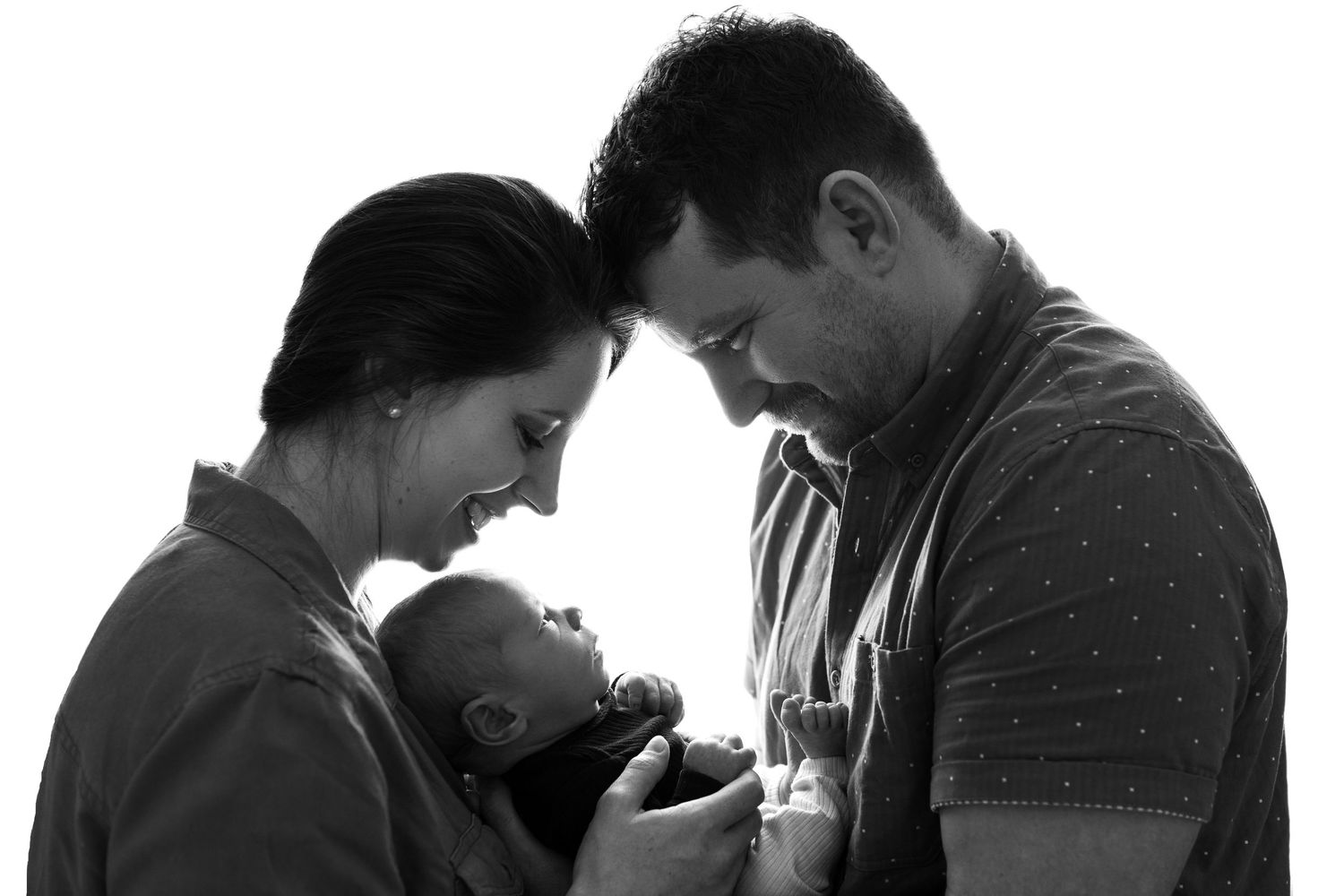 Silhouettes of family members in profile against white background. Newborn studio photoshoot Tauranga.