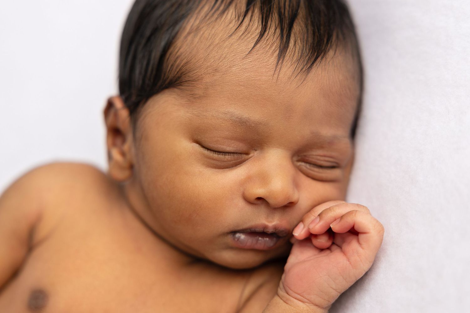 Baby showing various sleepy expressions while resting on white background.