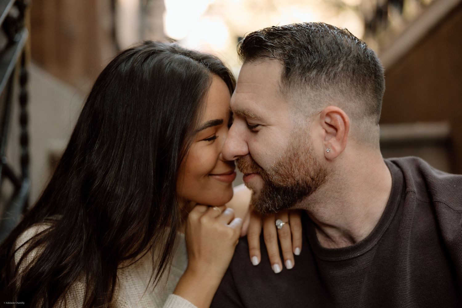 A close-up of a couple smiling while cuddled up together, capturing a moment of joy and affection.