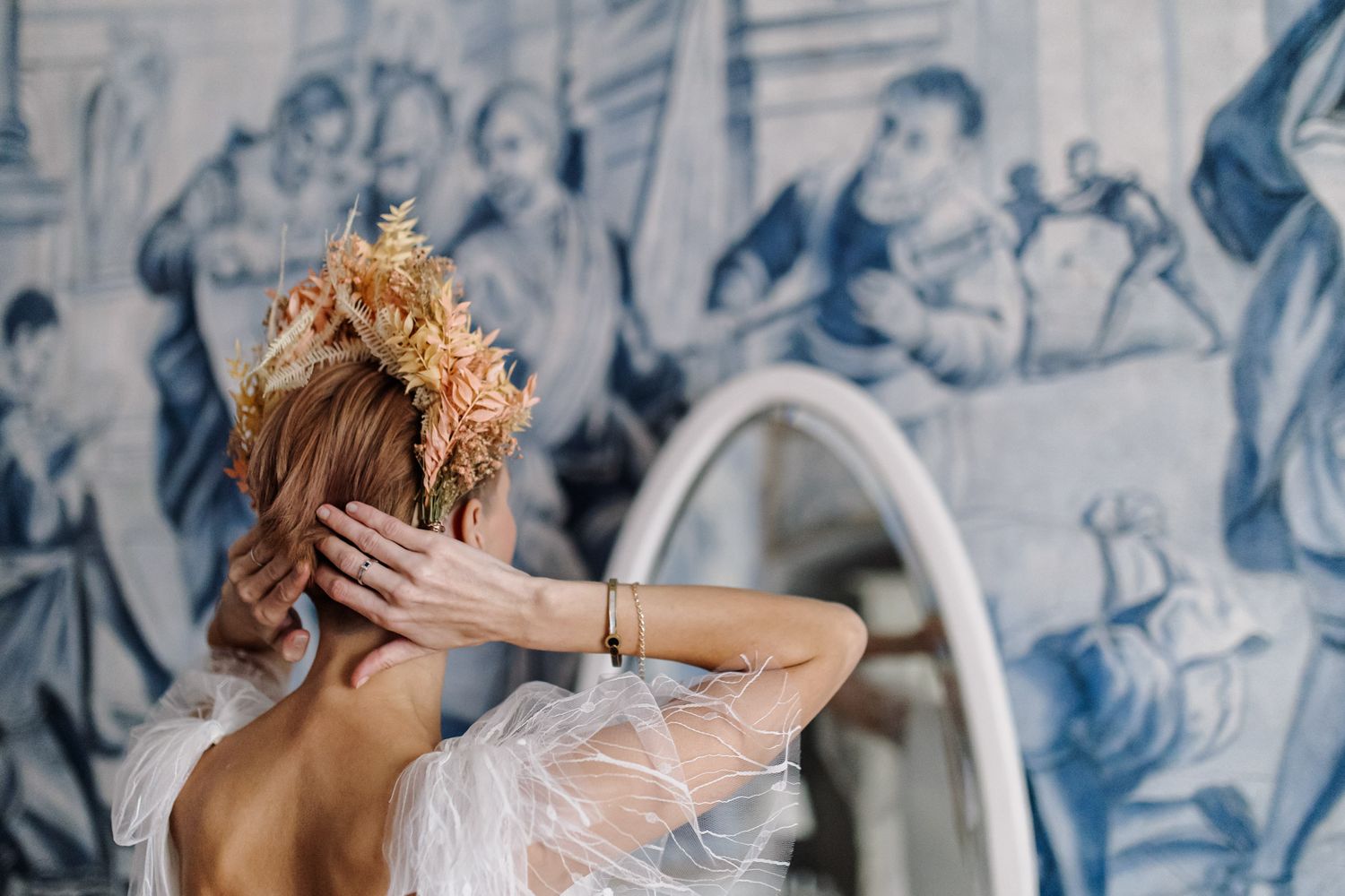 Artistic wedding photo showing dried floral crown against decorative wall mural.