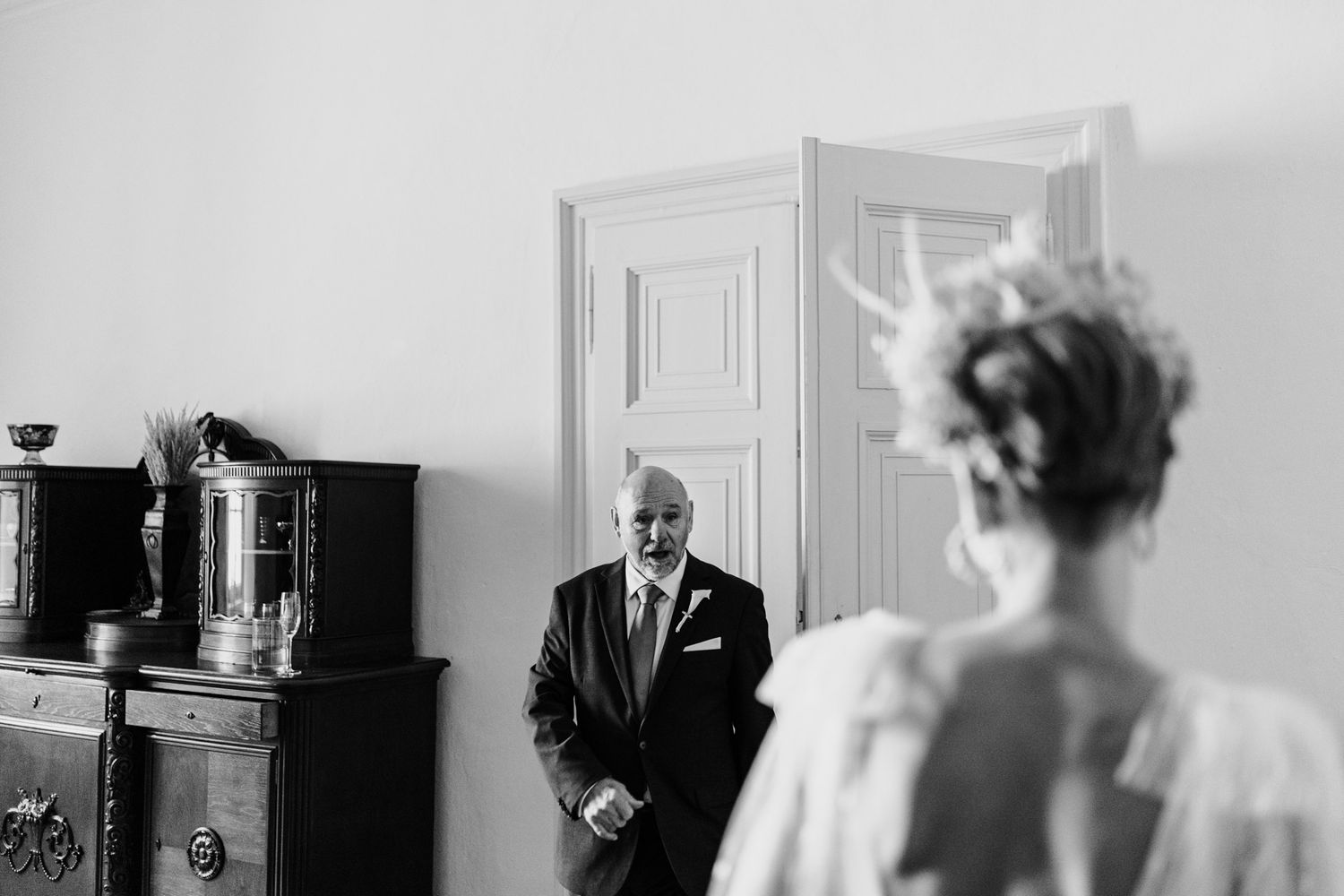 Emotional moment captured in black and white as guests gather before wedding ceremony.